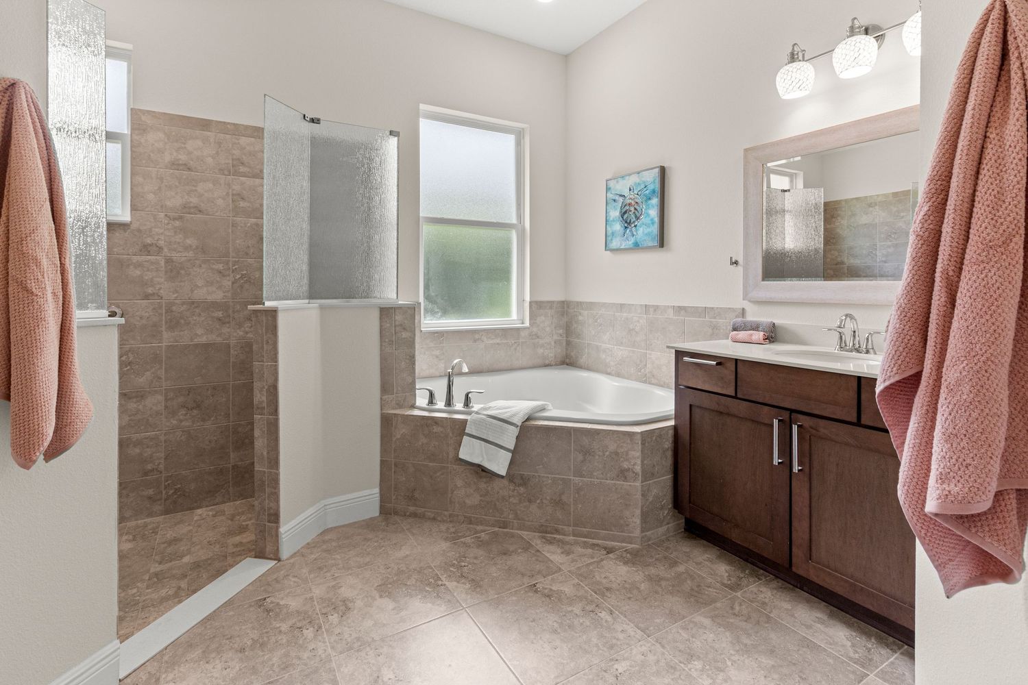Clean bathroom real estate photo featuring double vanity, walk-in shower, soaking tub, and bright natural light.