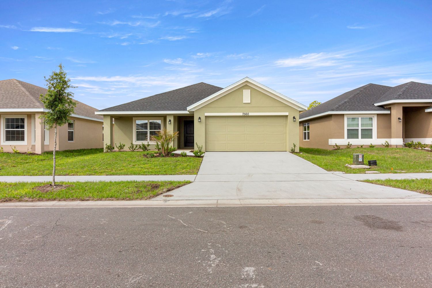 Wide-angle exterior shot of suburban home with driveway and landscaped lawn
