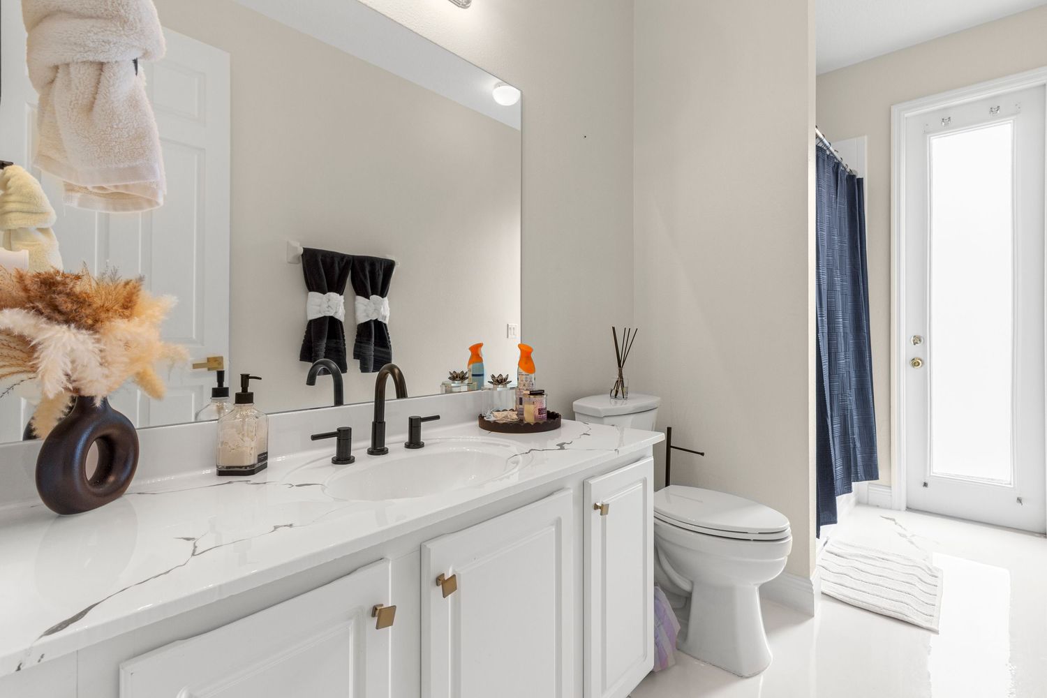 Beautiful Horizon West Florida bathroom with white shaker cabinets, quartz countertops, modern fixtures, and clean design. Professional.