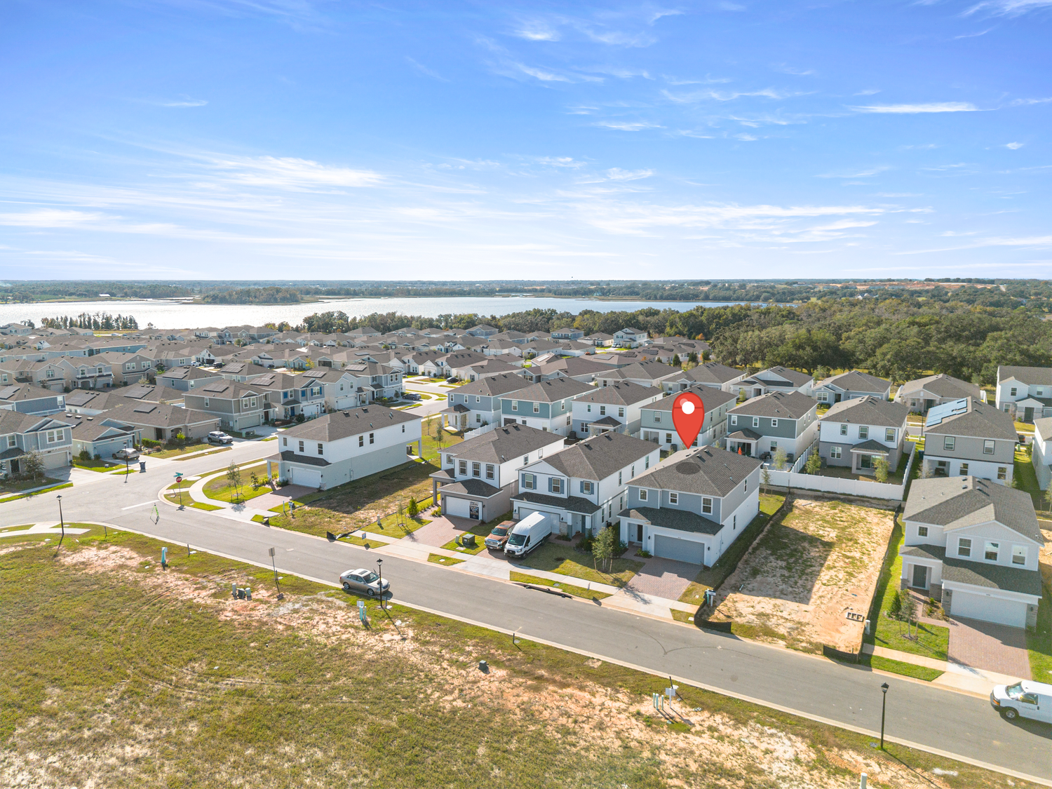 Professional aerial drone photography showcasing Florida neighborhood with property location marker. Expert real estate drone services.