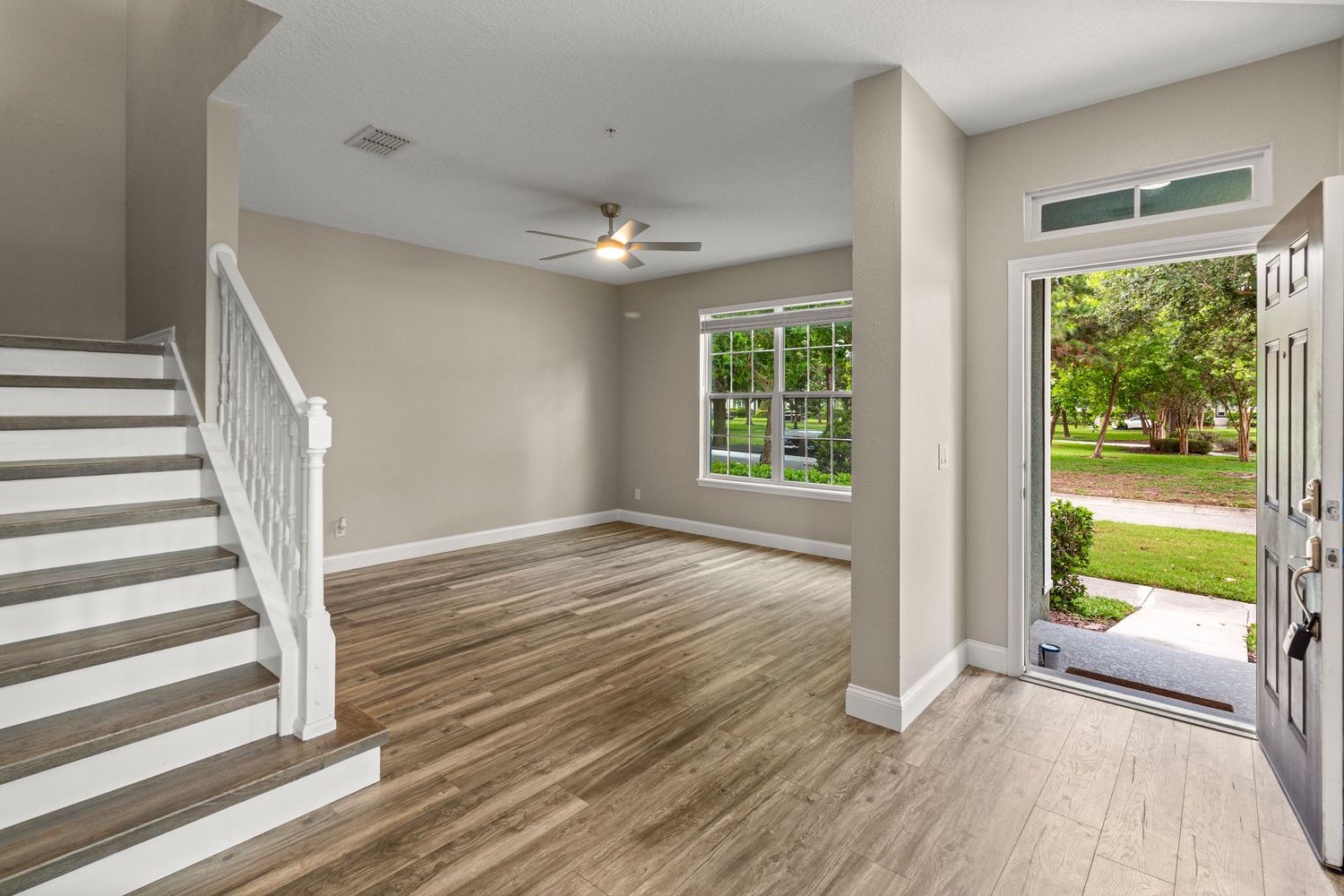 Inviting home entryway with staircase, open layout, natural light, and clean real estate photography composition.
