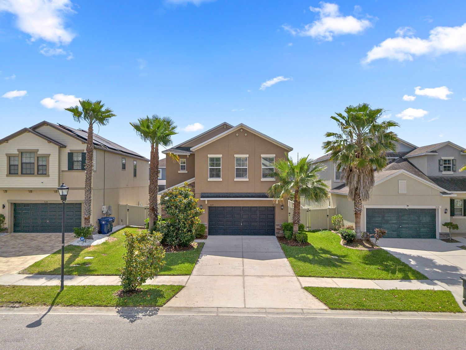 Beautiful suburban home exterior with driveway, garage, and palm trees – Central Florida real estate photography