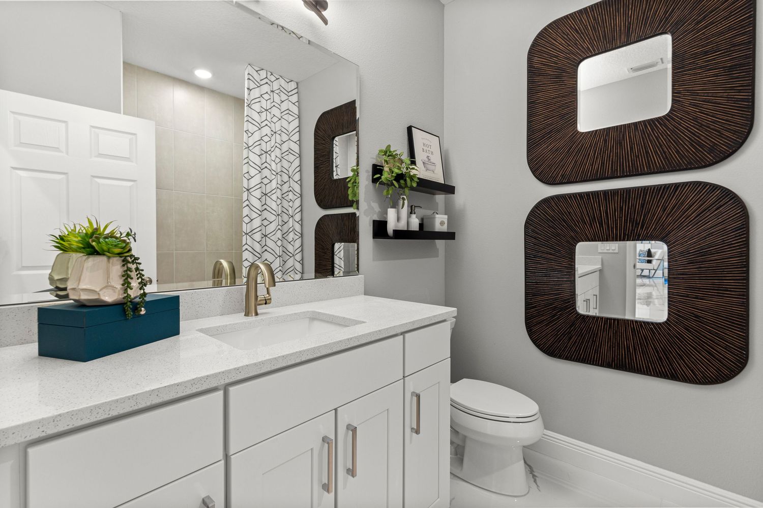 Modern bathroom interior design in Celebration Florida featuring white shaker cabinets, marble countertops, and contemporary mirrors.