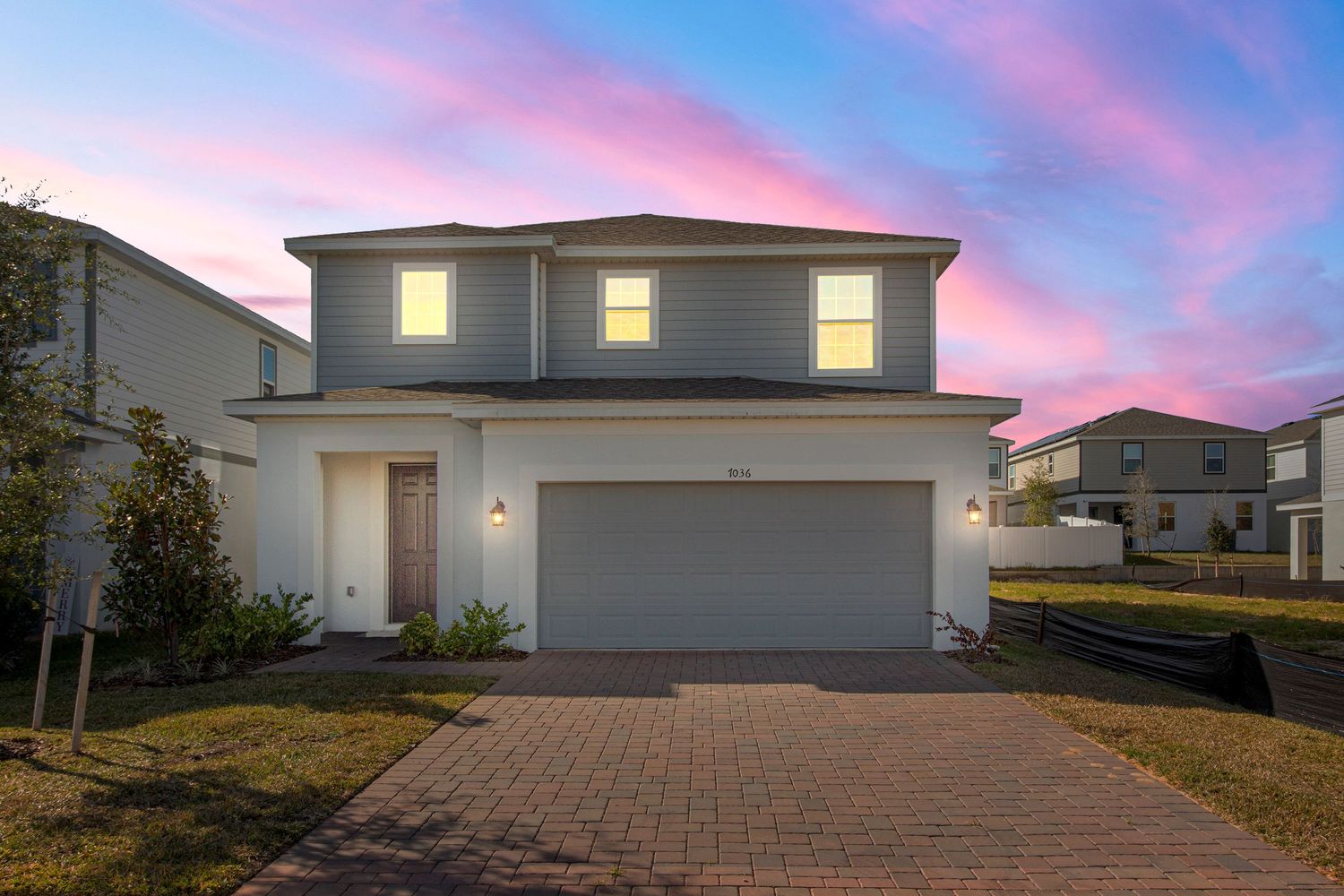 Stunning virtual twilight real estate photography showcasing Florida home exterior with enhanced sunset sky and dramatic dusk lighting.