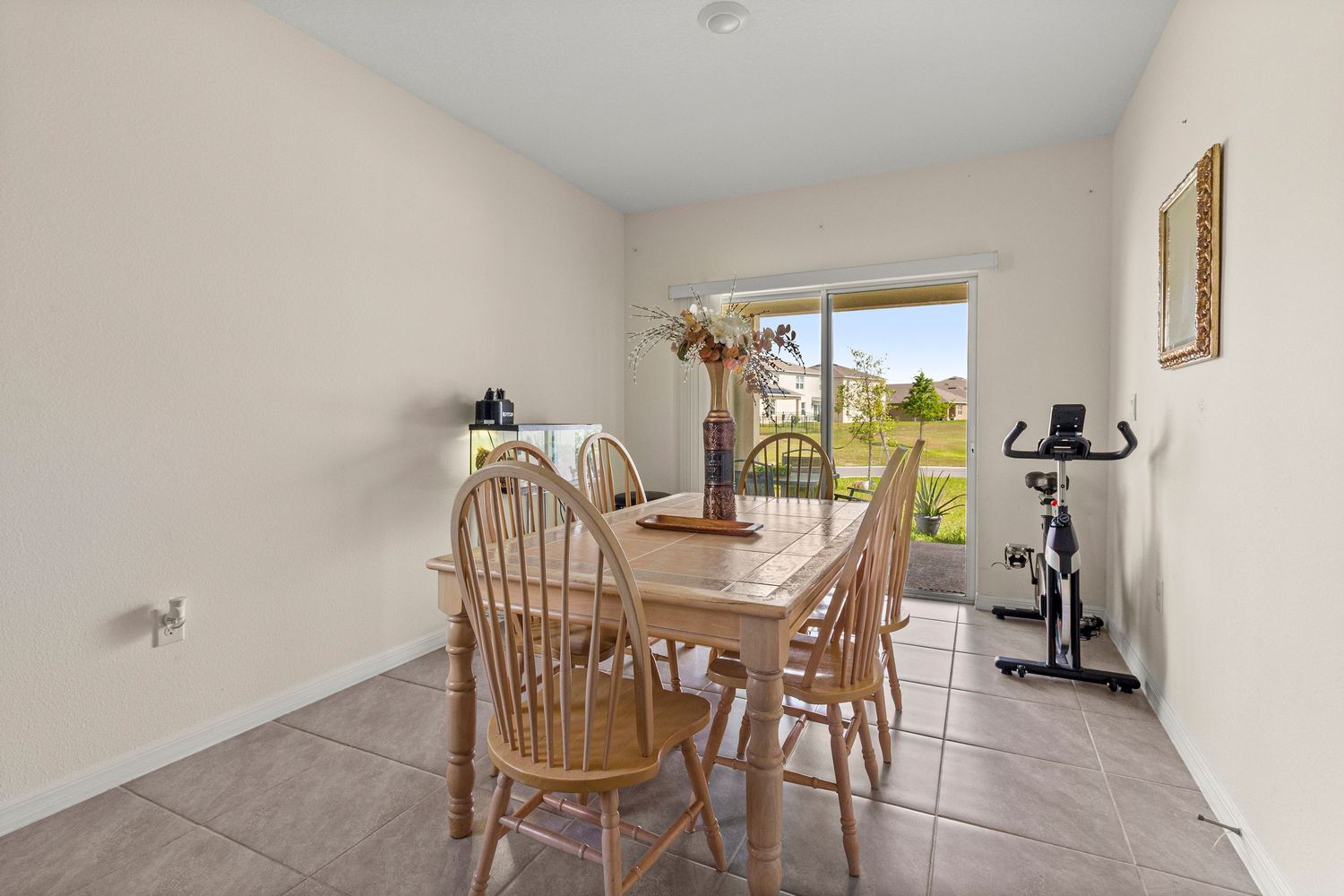 Bright dining area with natural light, tile floors, and backyard view in Central Florida home