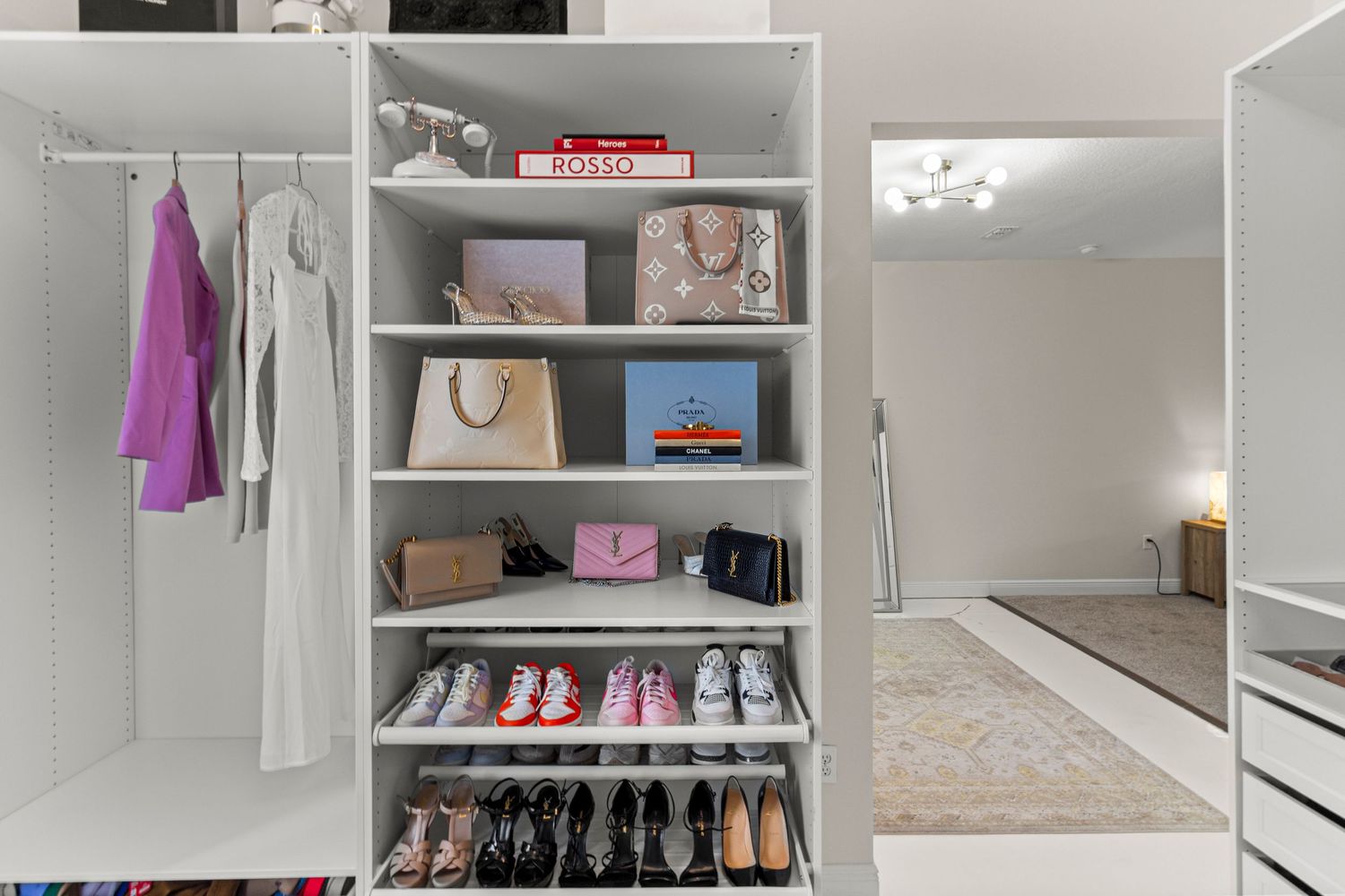 Well-organized Osceola County Florida walk-in closet with built-in shelving, shoe storage, hanging rods, and efficient layout. Professional