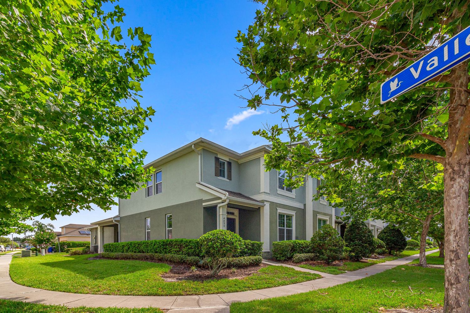 Corner-lot home exterior with green landscaping, mature trees, and professional Central Florida listing photography.