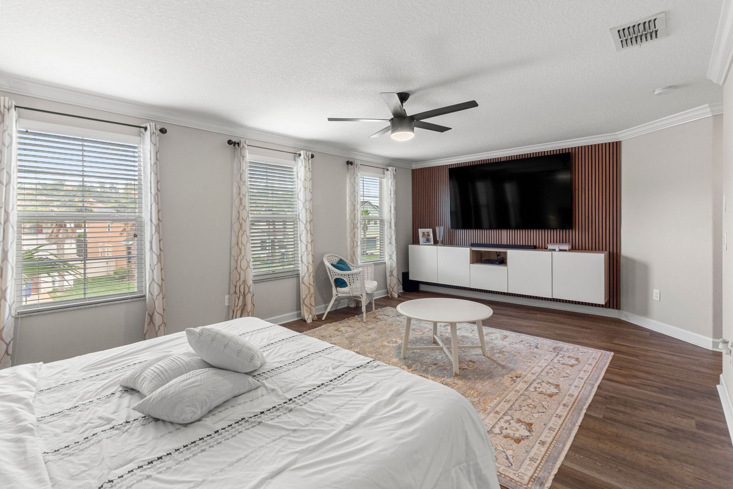 Modern master bedroom with natural light, hardwood floors, and open living area – Central Florida real estate photography