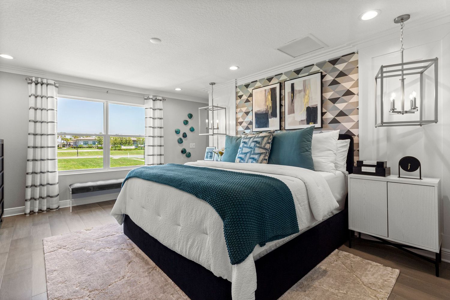 Luxurious Davenport Florida master bedroom featuring teal accent bedding, plaid window treatments, white nightstands, and spacious layout.