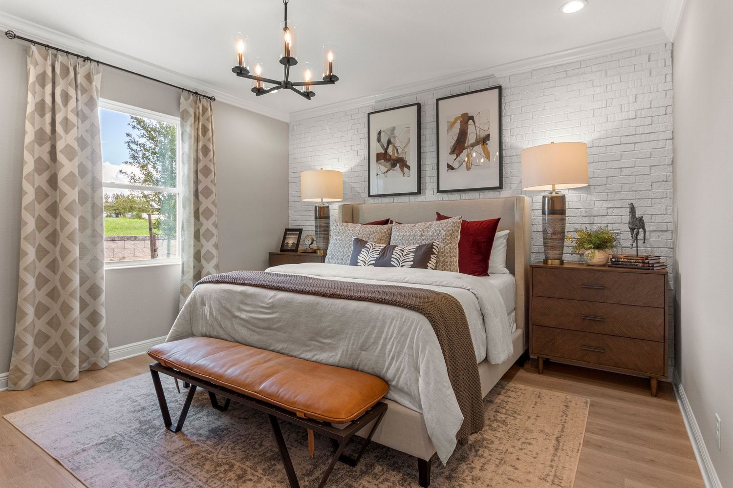 Cozy Groveland Florida bedroom with neutral bedding, warm wood furniture, framed artwork, and natural lighting. Professional Lake County.