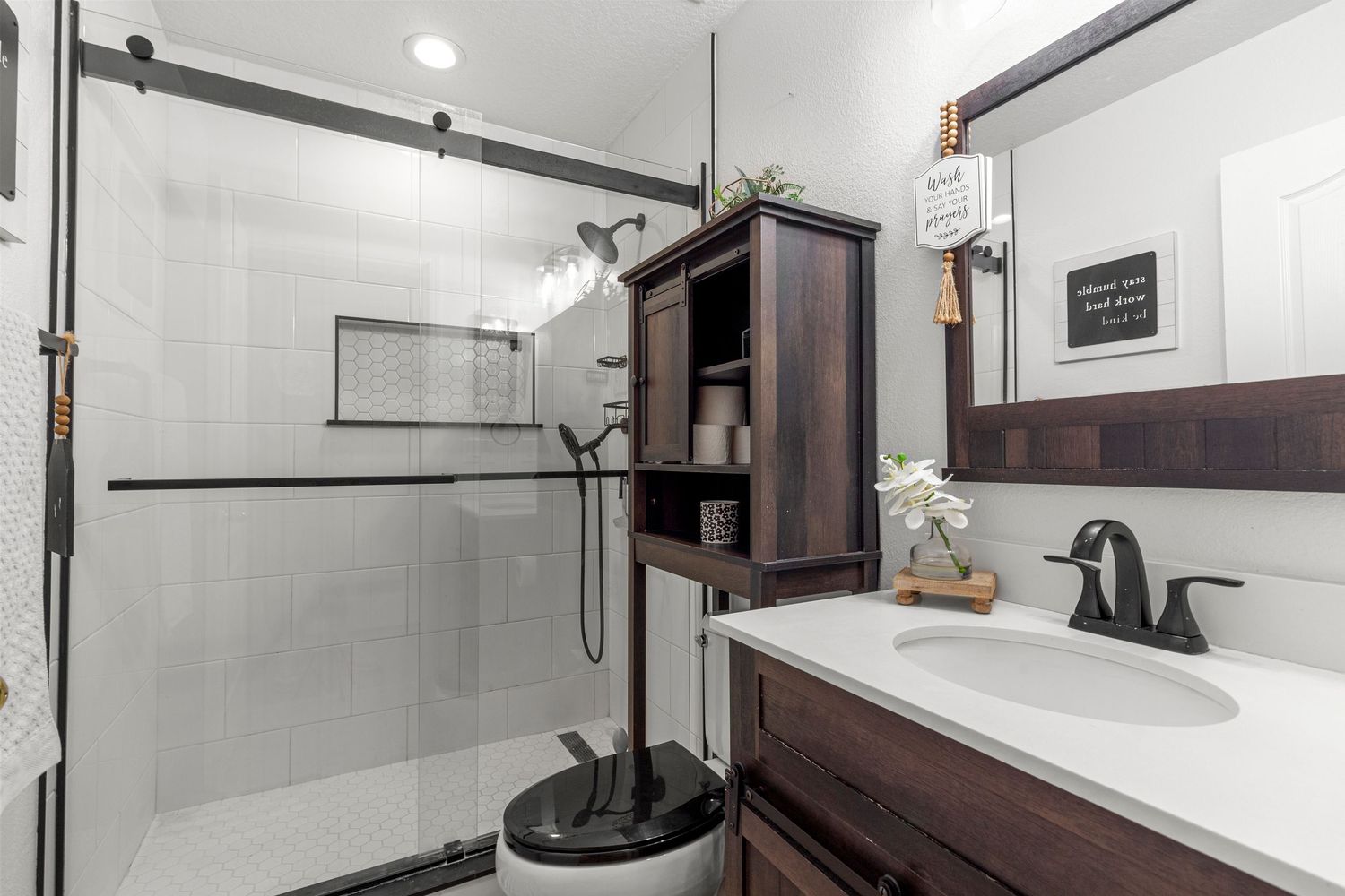Fresh remodeled Kissimmee Florida bathroom featuring glass shower door, modern vanity, white subway tile, and updated fixtures. Professional