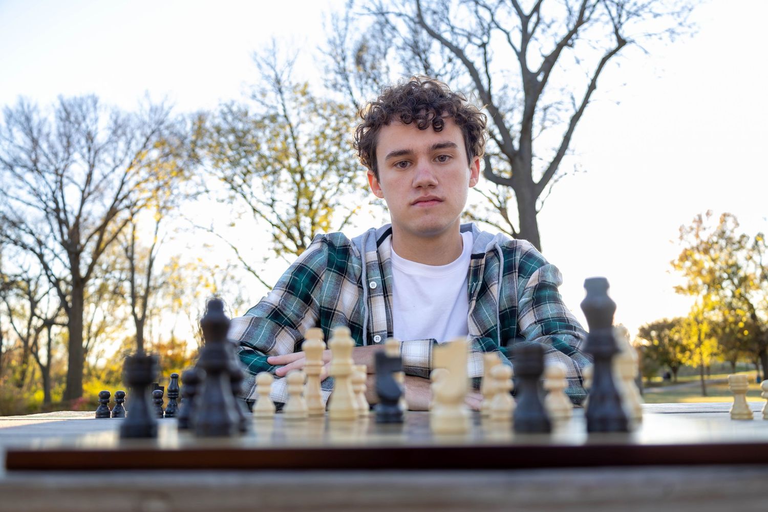 A senior who enjoys chess, senior session with Refined by fire photography during golden hour at at Nathanael Greene Park in Springfield MO