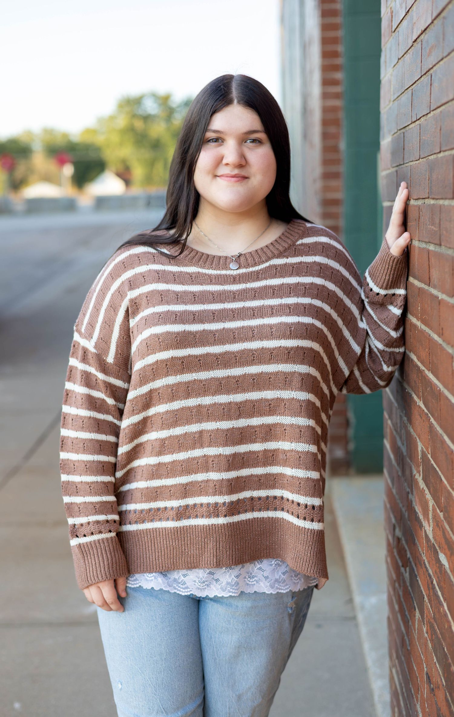 homeschool senior leaning against wall during her session on commercial street.
