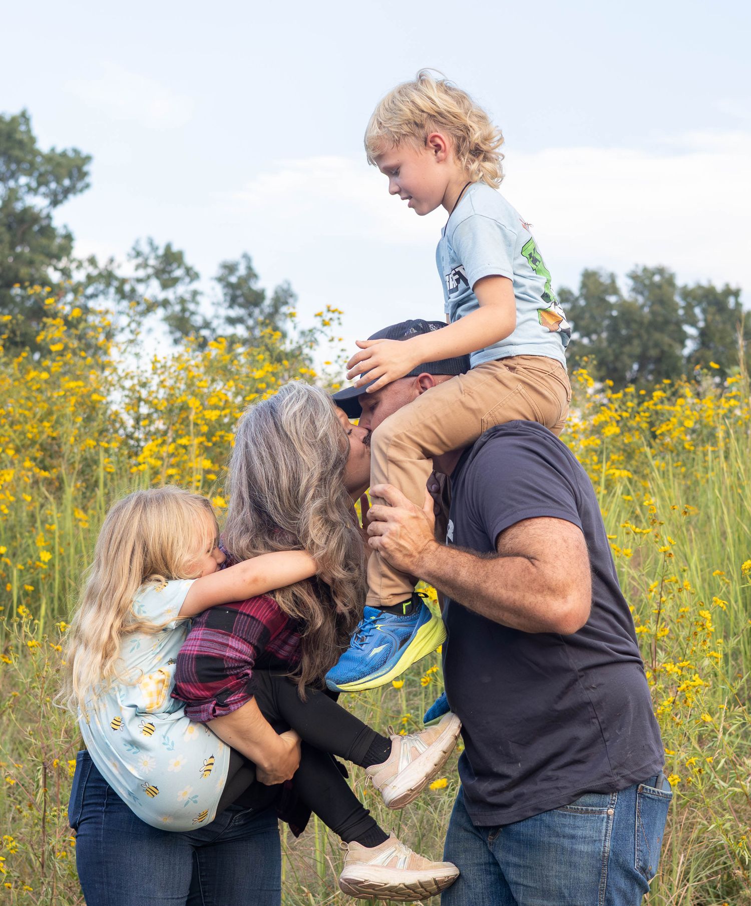 Family of 4 playing on their property during a session with Refined by Fire Photography located in Conway MO