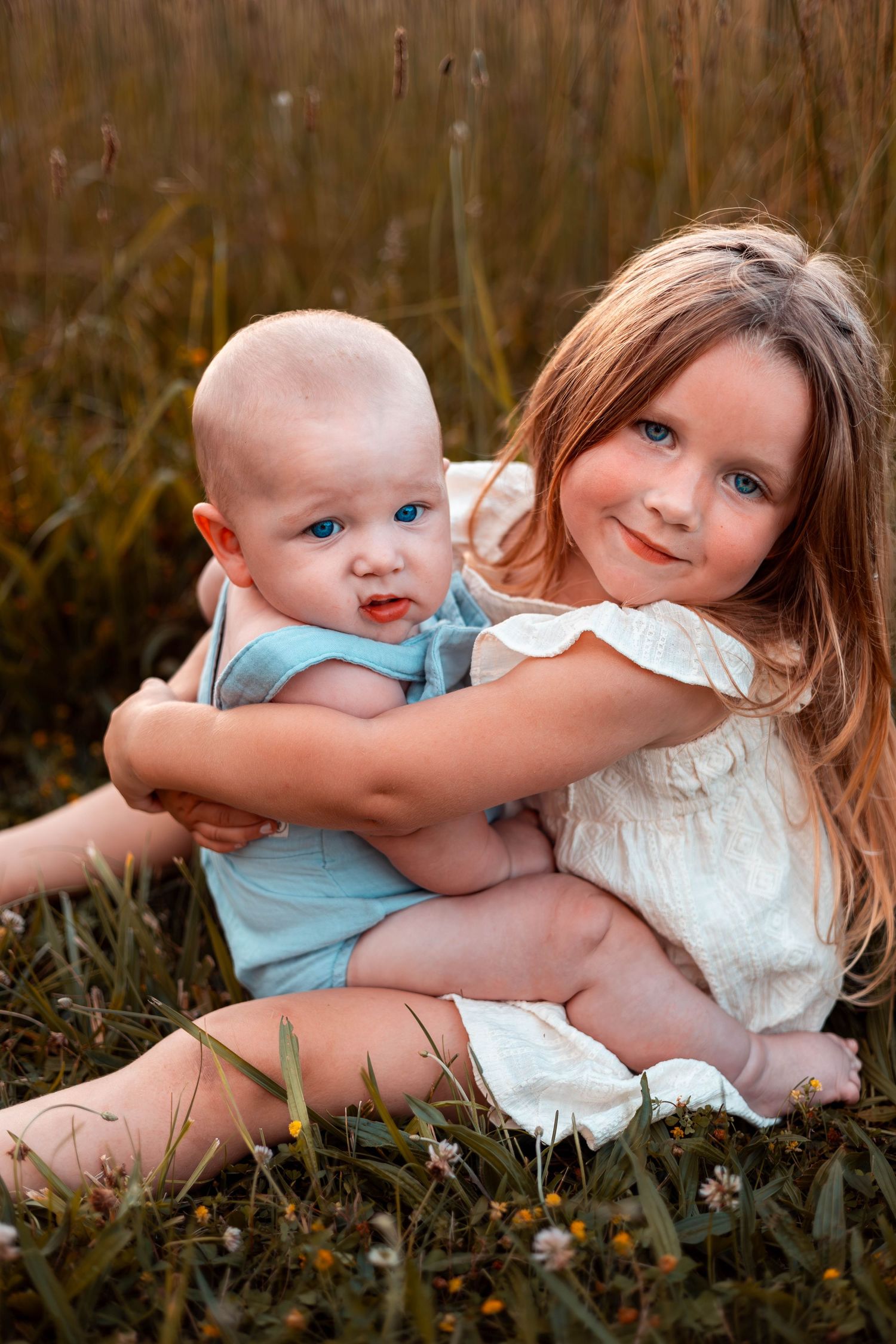 Sibling session in Springfield MO, Southwest MO, hugging each other in a field.