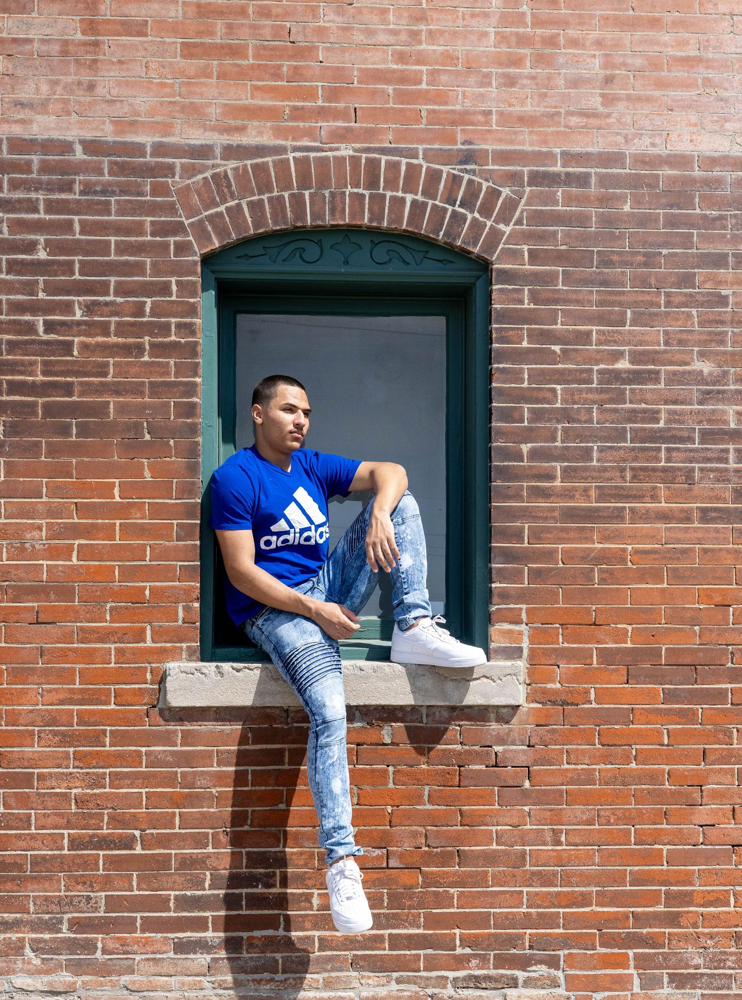 Male Senior sitting on a window in Southwest Missouri watching cars go by on Commercial street.