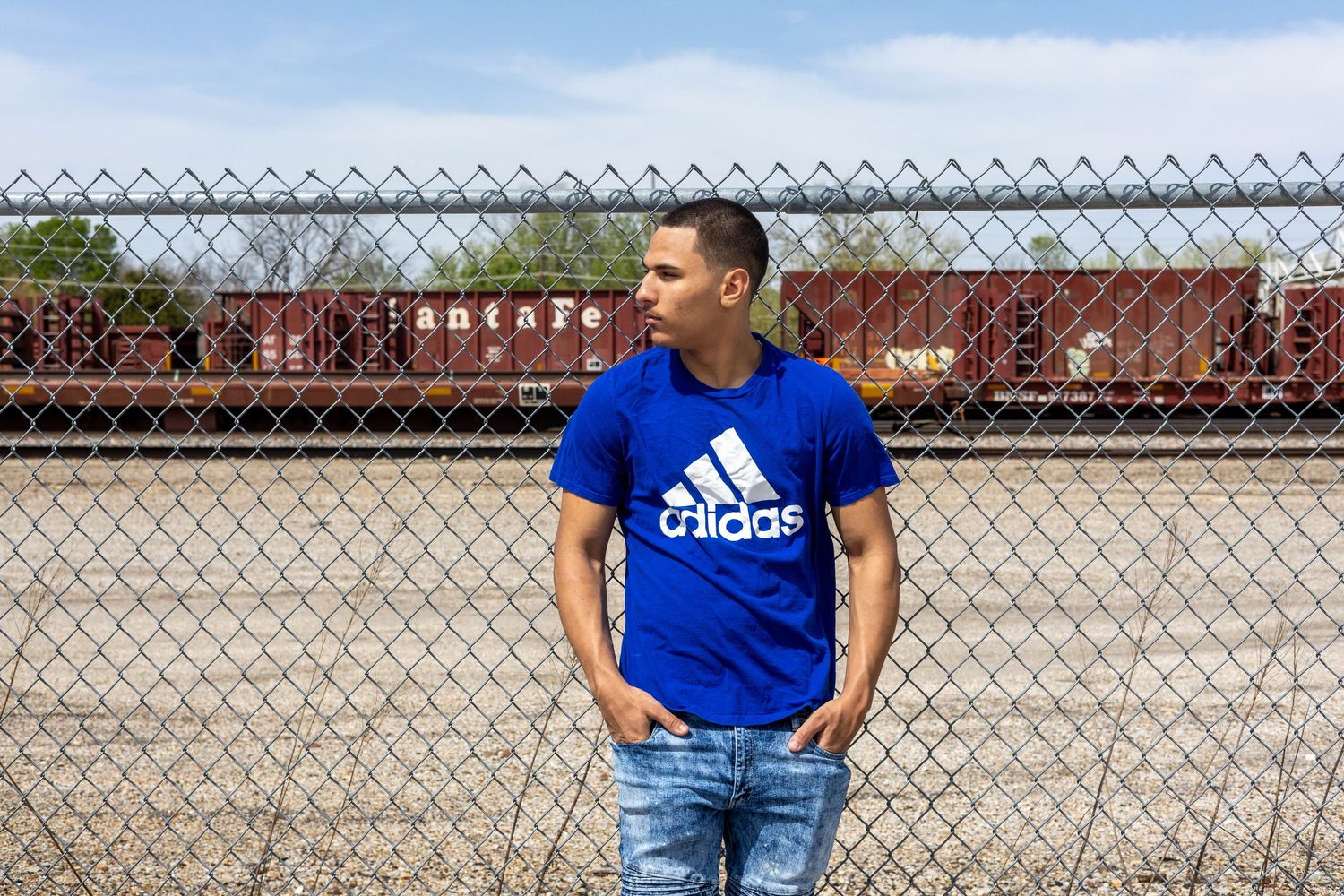 Senior  watching the train go by off commercial street in Springfield Missouri during his senior session with Refined by Fire Photography