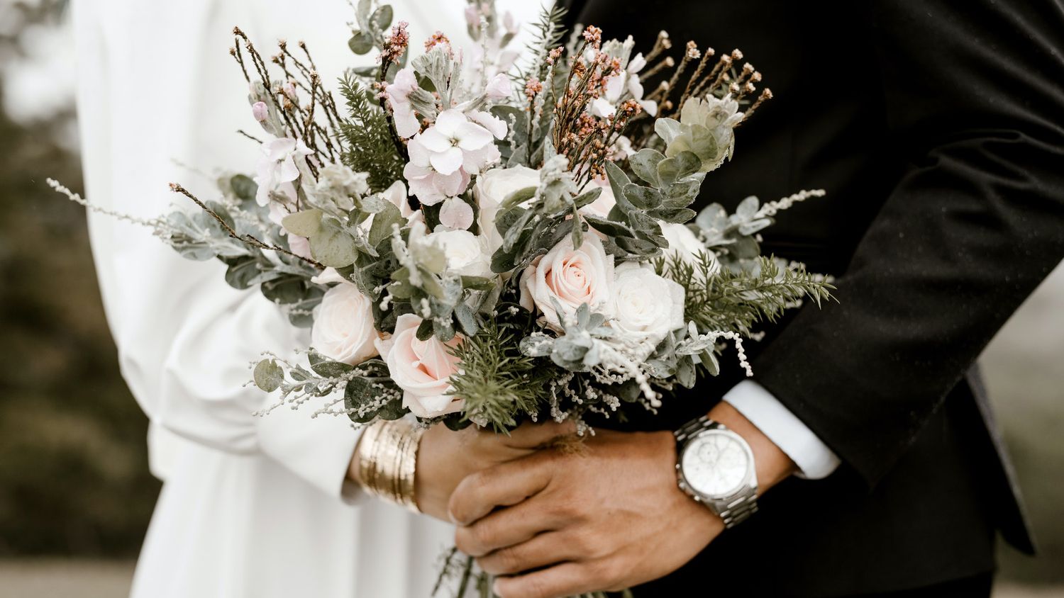 Beautiful white and pink floral wedding bouquet with delicate flowers and greenery.