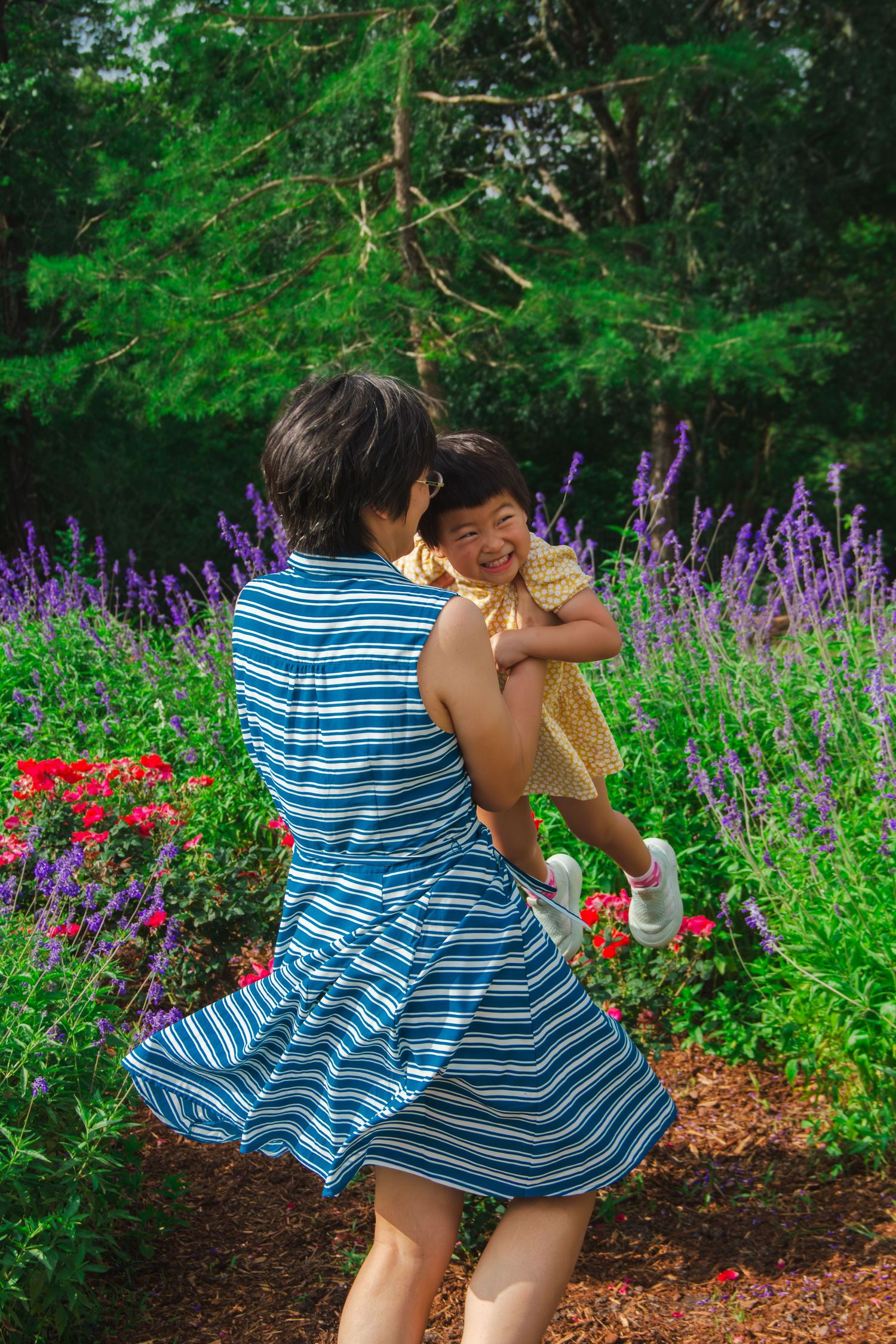 Mom and daughter spinning in the flowers