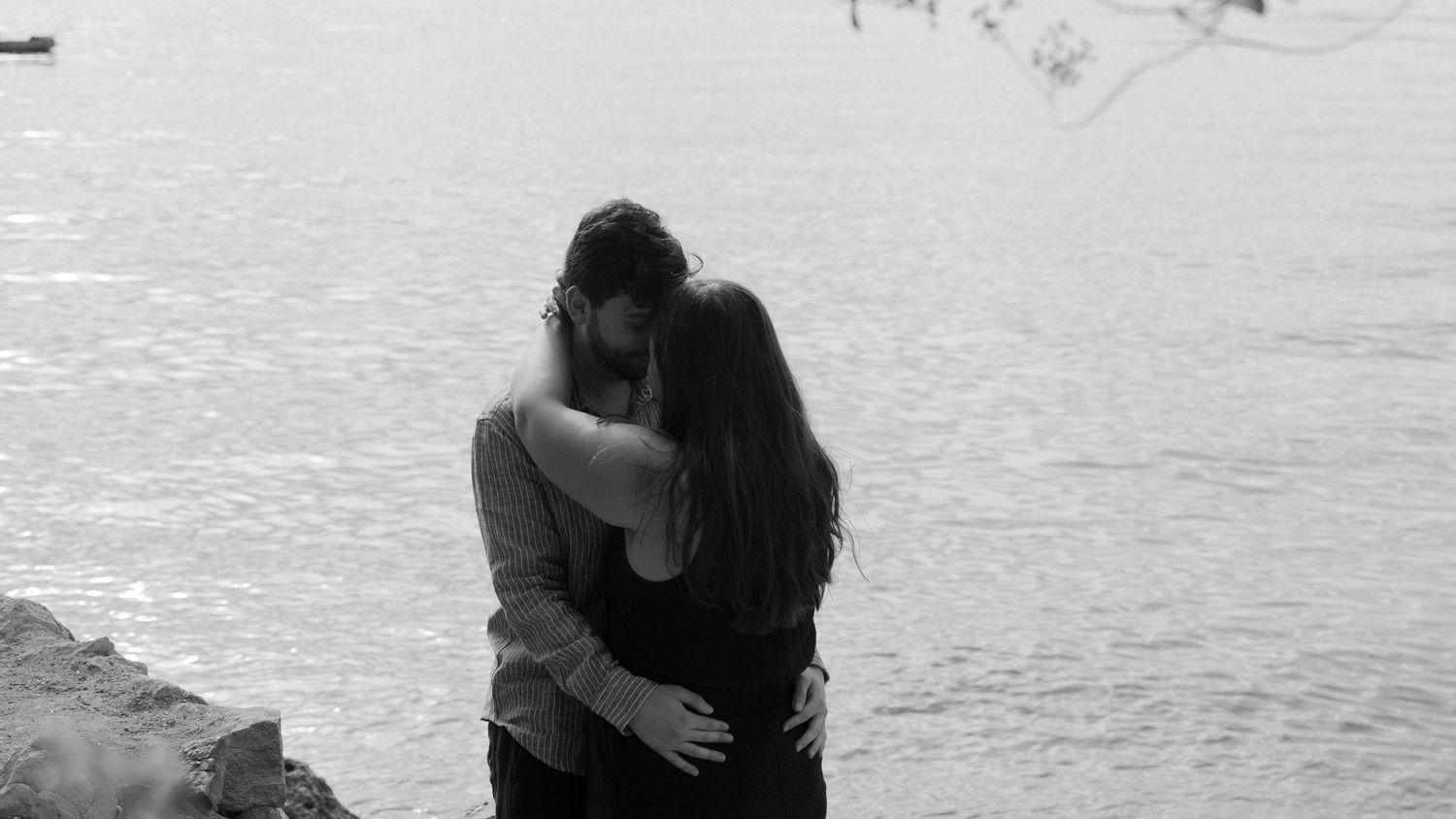 A series of six black and white photographs showing tender moments between a couple at the beach.