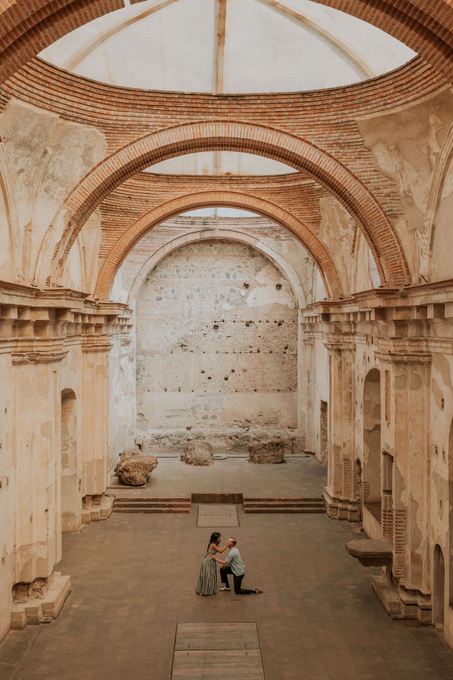 Panoramic view of ancient Roman baths with arched ceilings and brick walls showing architectural details in warm sepia tones.