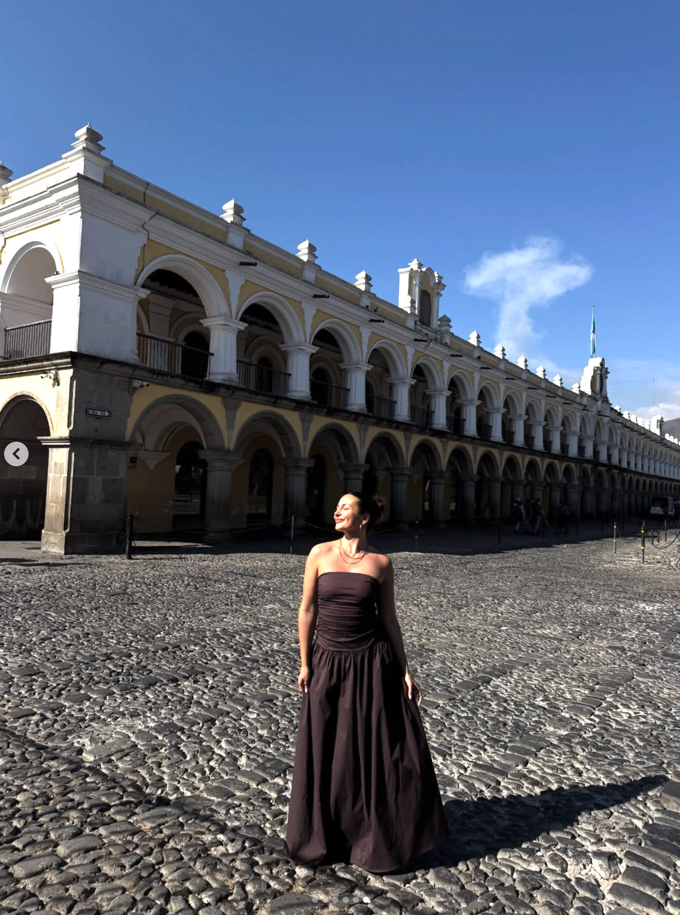 Historic colonial arches and cobblestone courtyard of Antigua Guatemala's San Jose el Viejo ruins under blue sky.