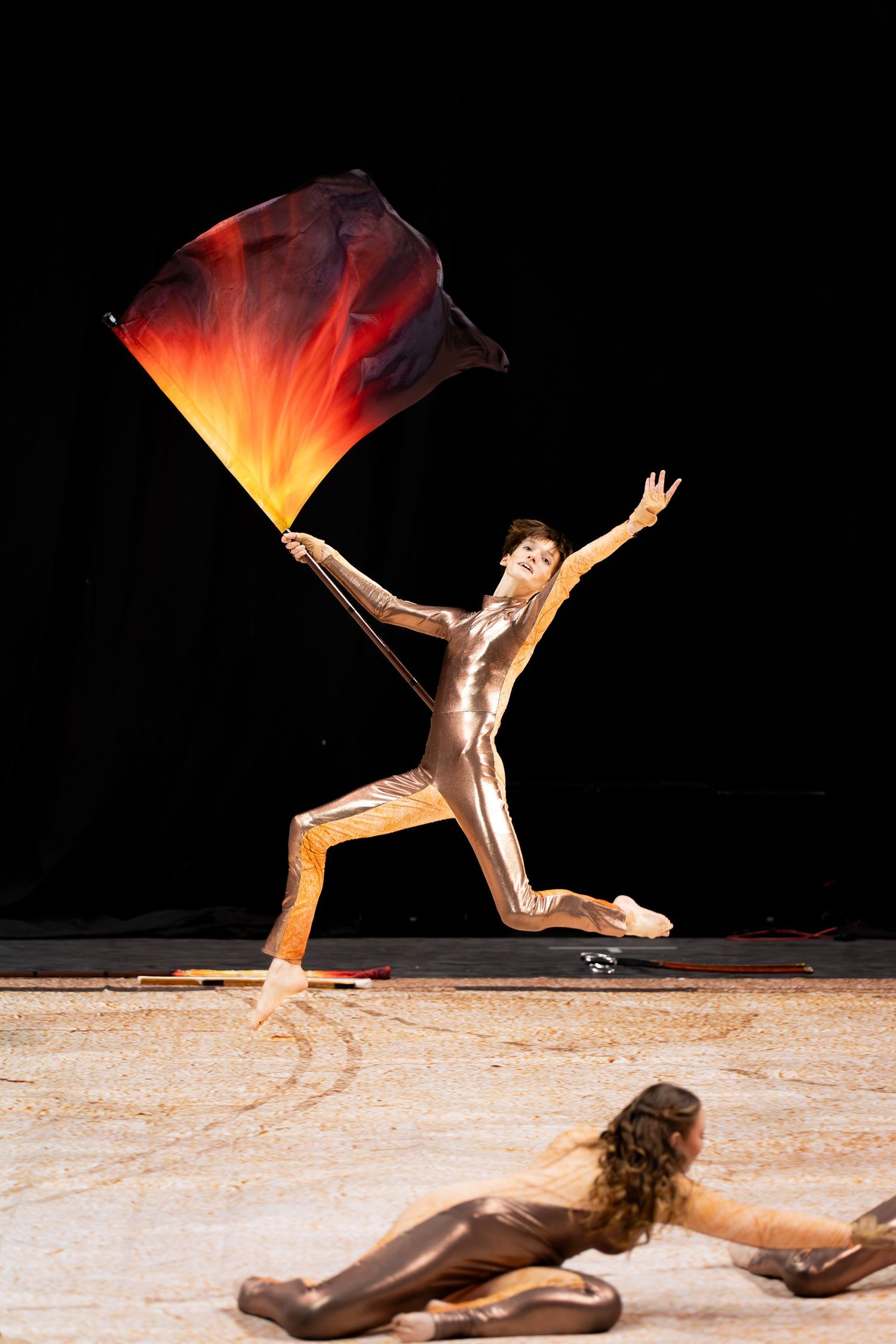 A winter guard performer leaps through the air