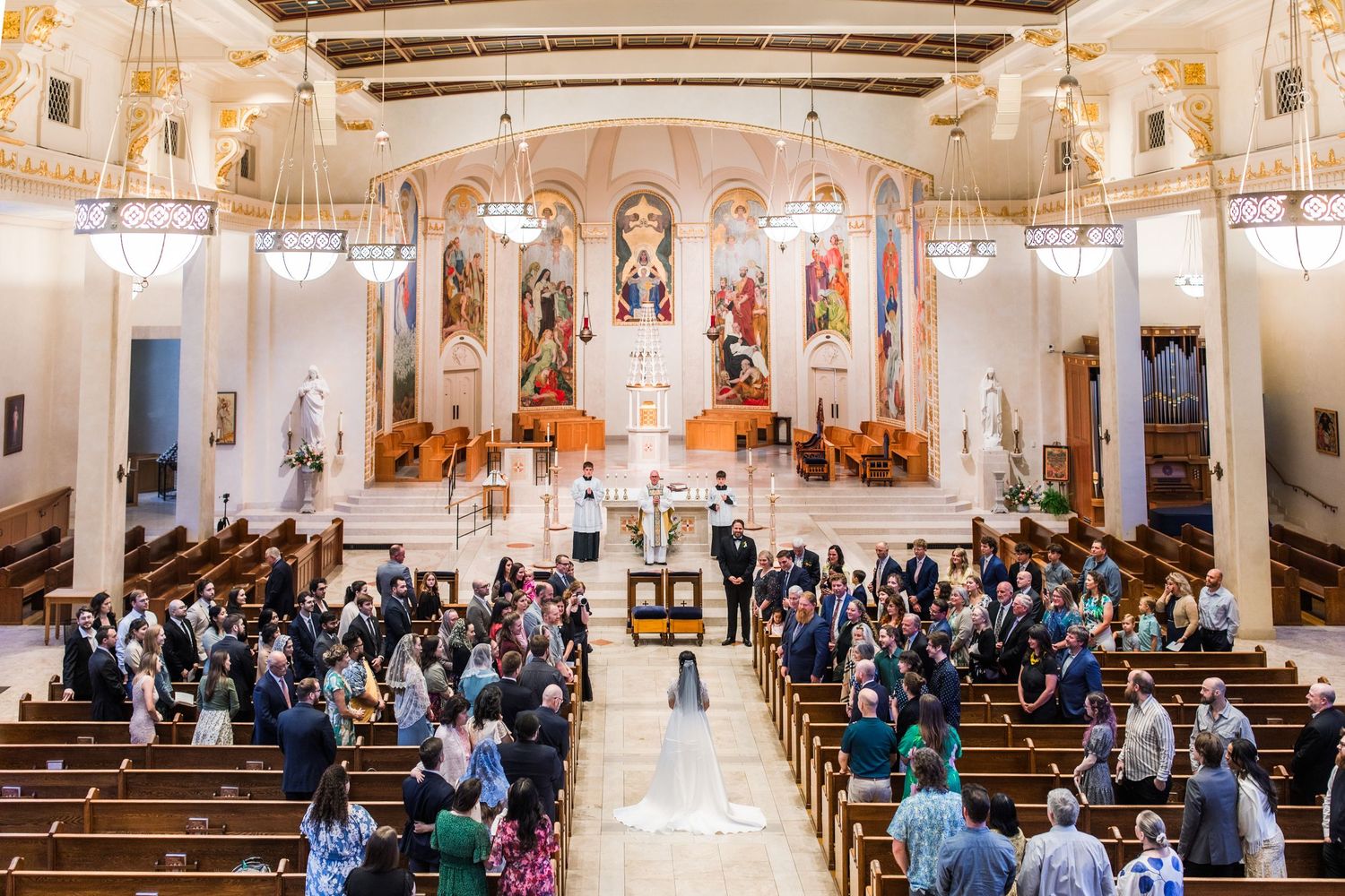 Panoramic view of church interior with congregation seated during ceremony.