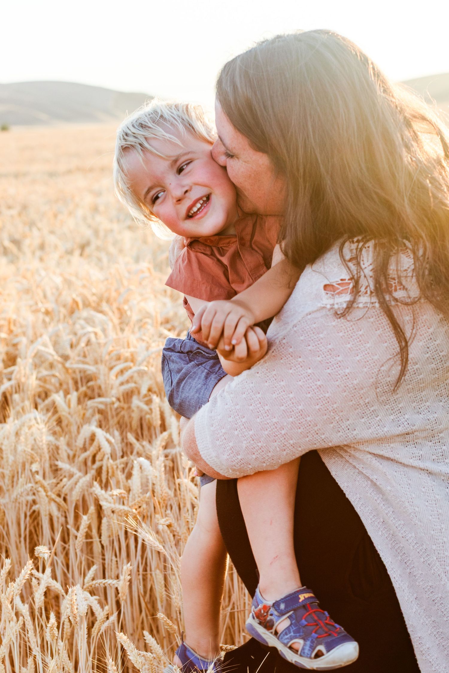Sweet moment captured in golden wheat field during sunset.
