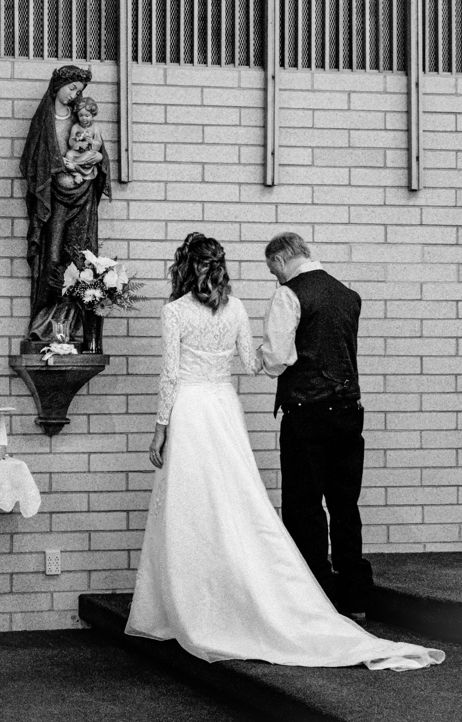 A sequence of photos showing a wedding dress being put on against a brick wall.