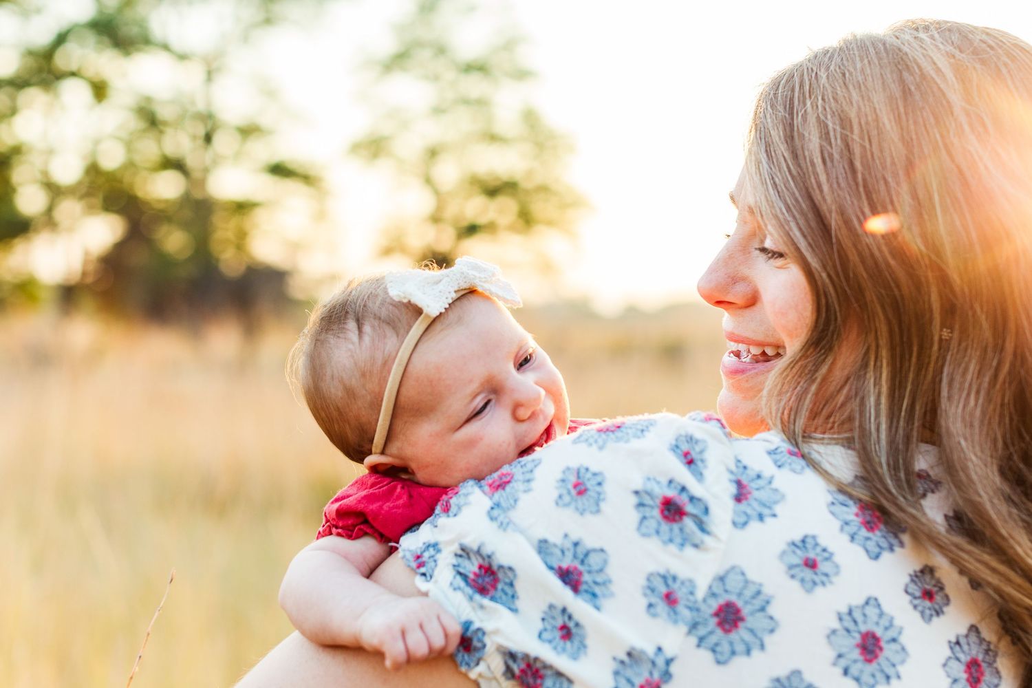 Family portrait session in a sun-drenched field during golden hour.