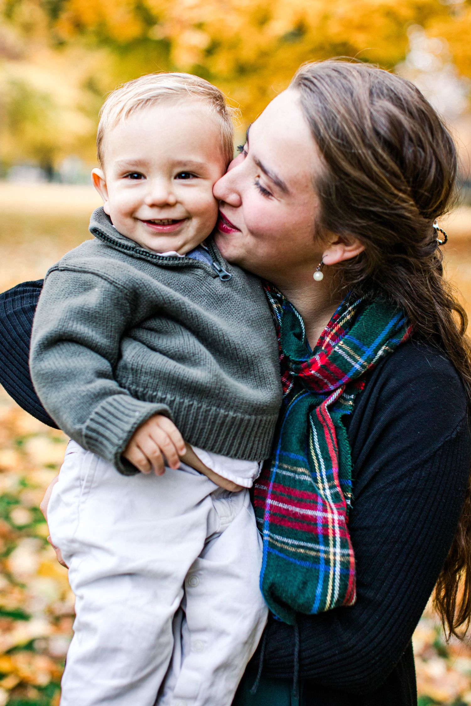 Candid moments of affection captured outdoors during fall season.