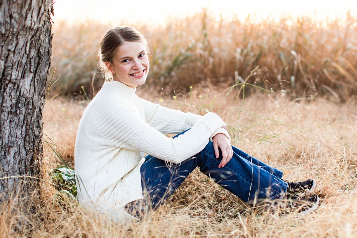 Casual outdoor portrait session near trees during golden hour.