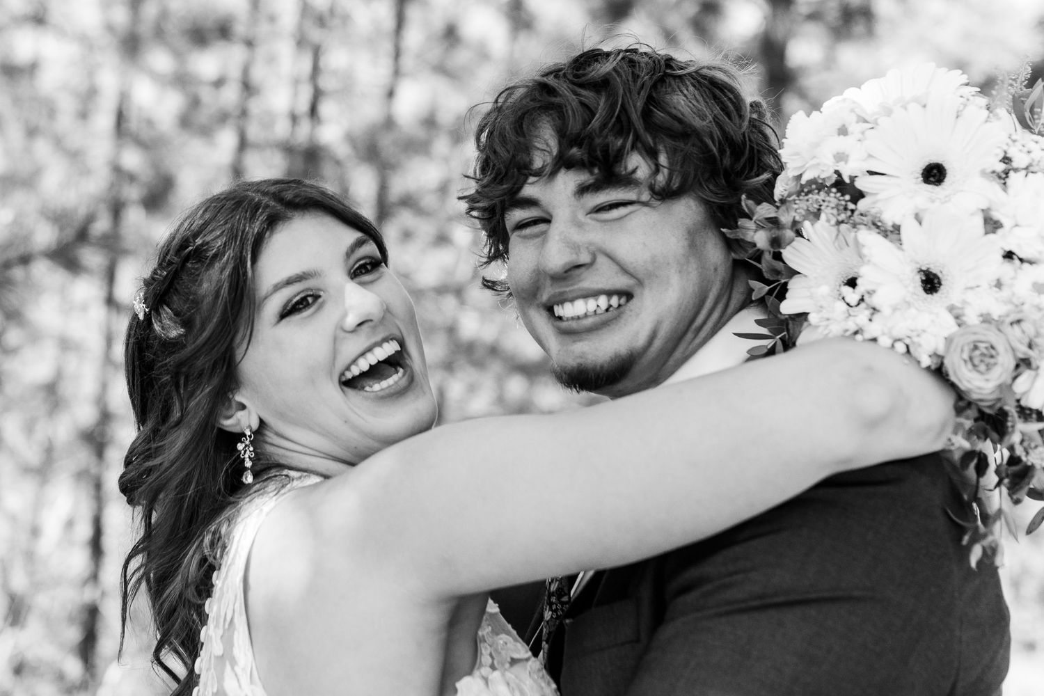 Joyful black and white portrait of couple laughing together outdoors.
