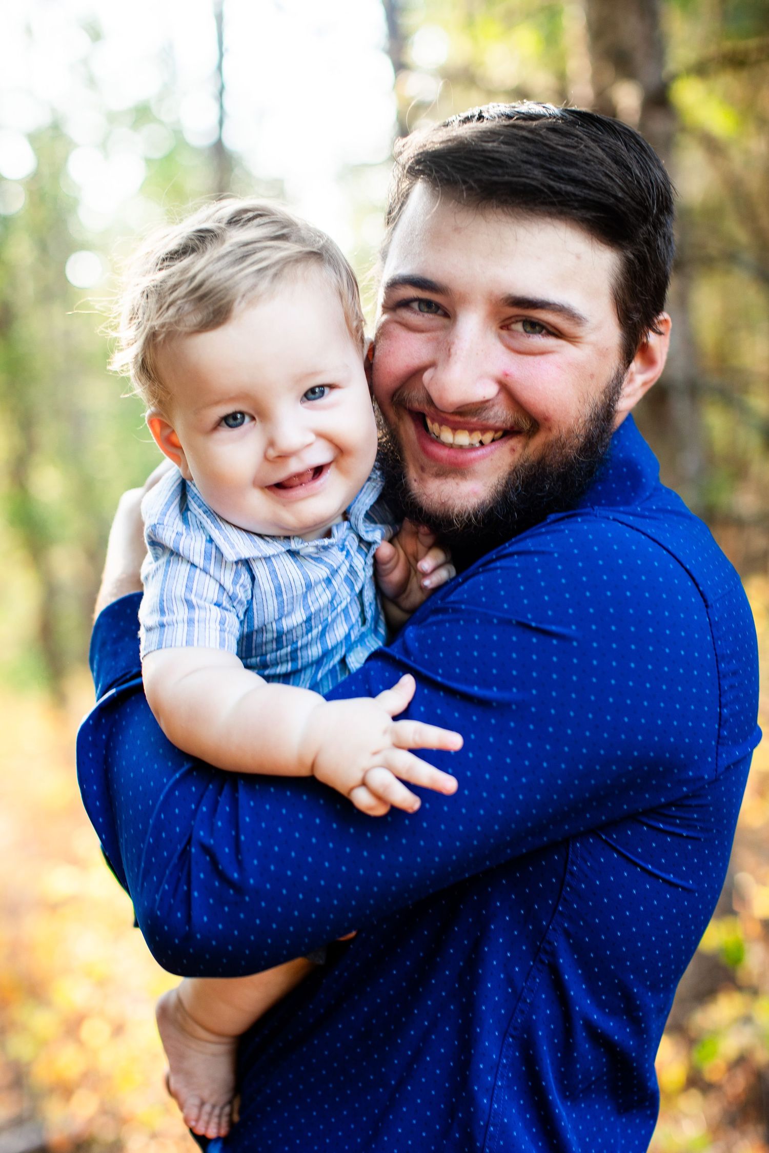 Joyful parent-child embrace captured outdoors in autumn setting.
