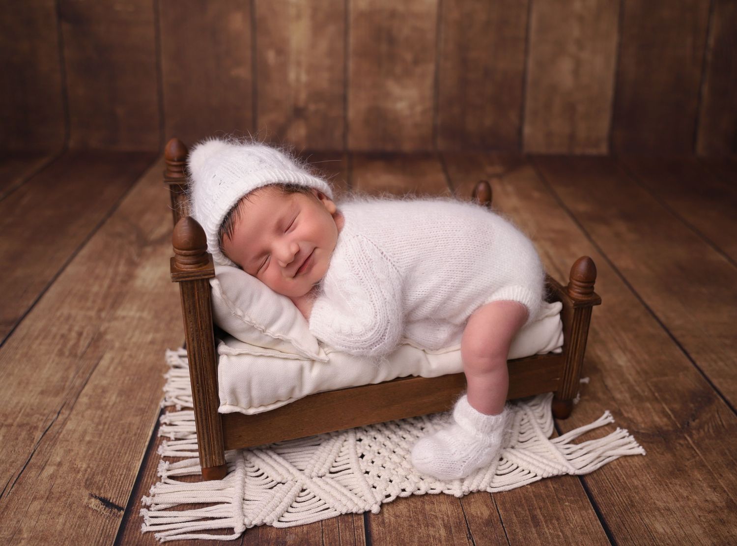 A series of photos showing a sleeping baby on rustic wooden floorboards with white fabric and lace details.