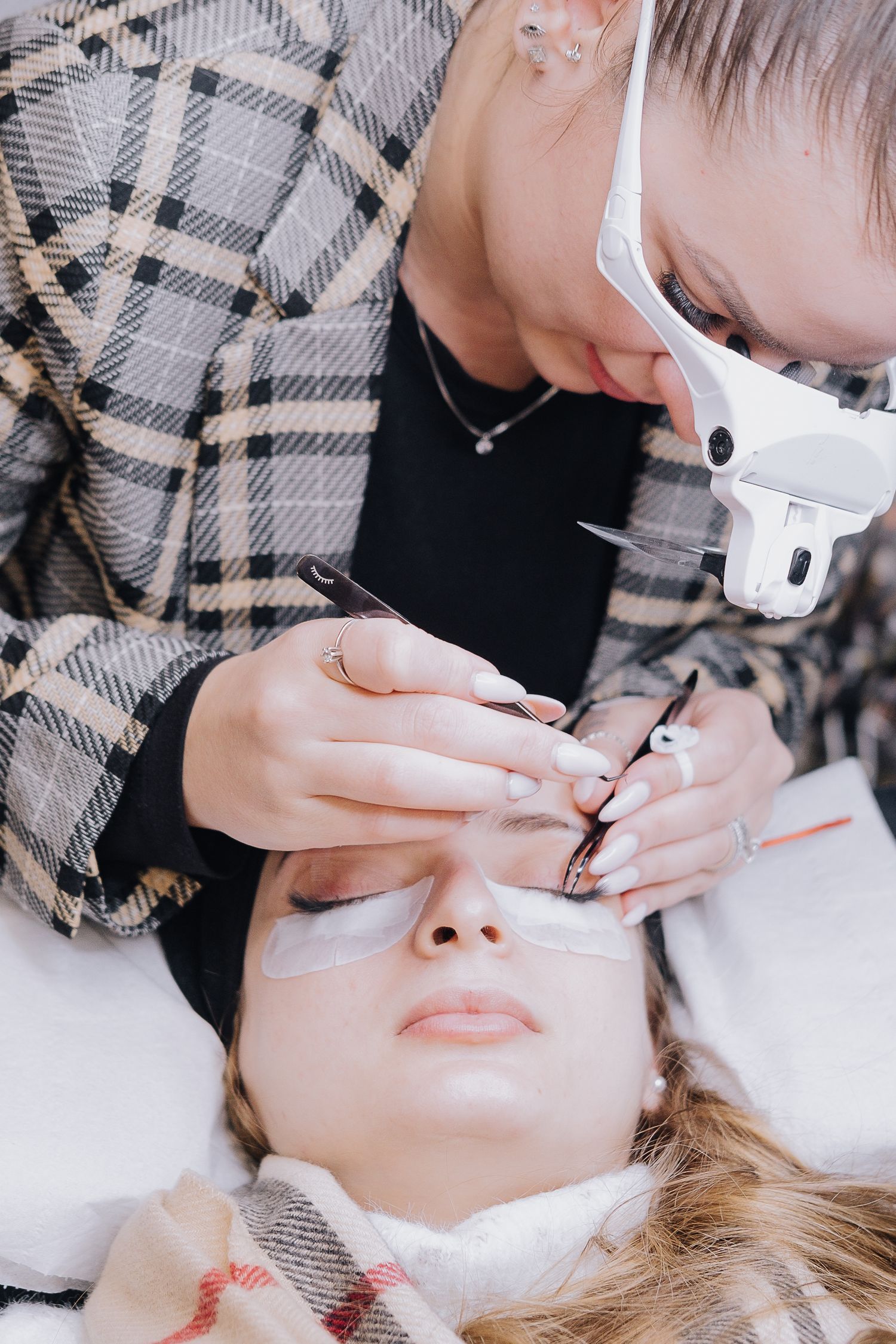 Professional eyelash extension application in progress at a beauty salon.