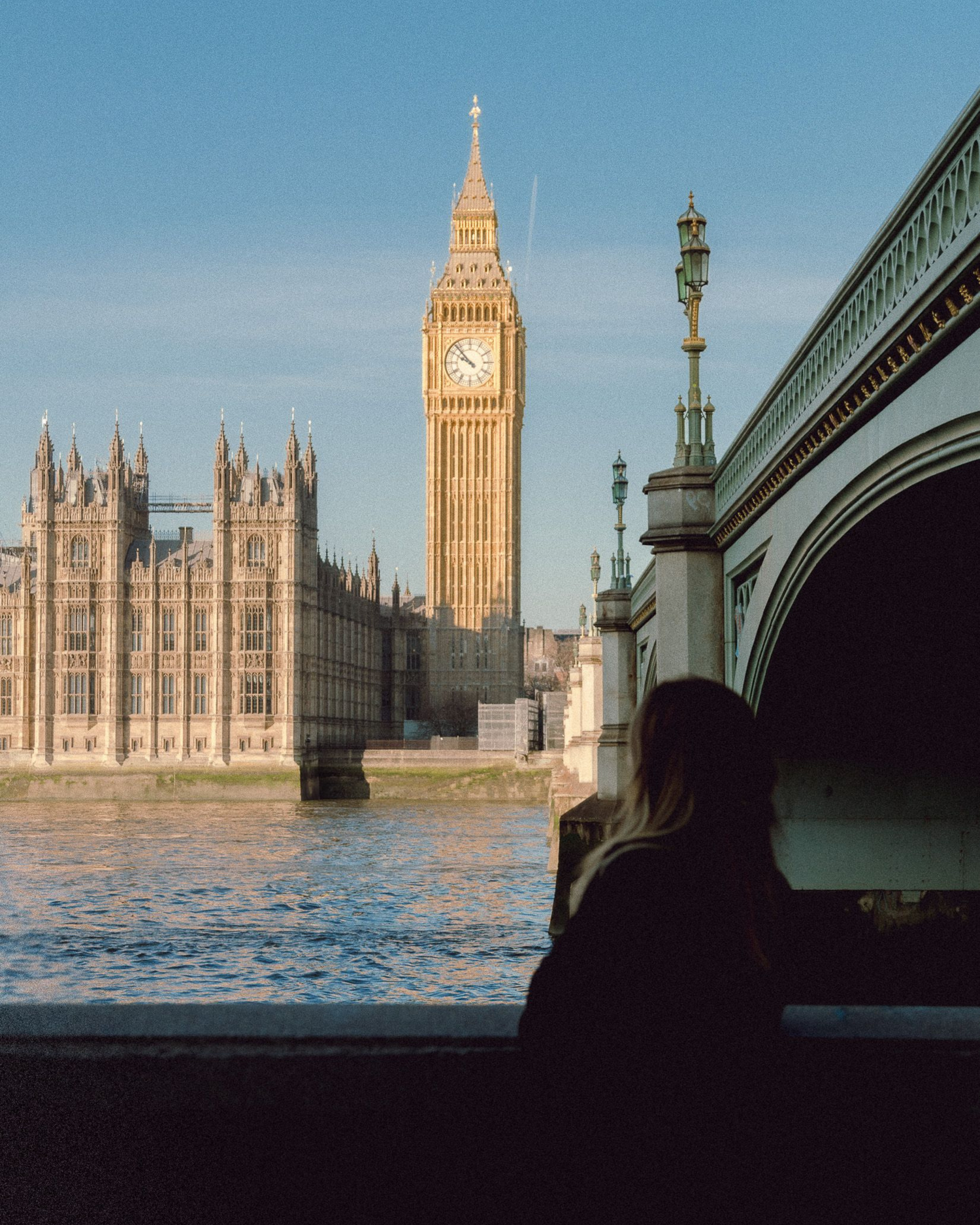 Classic view of Big Ben and Houses of Parliament along the River Thames with Westminster Bridge at sunset in London.
