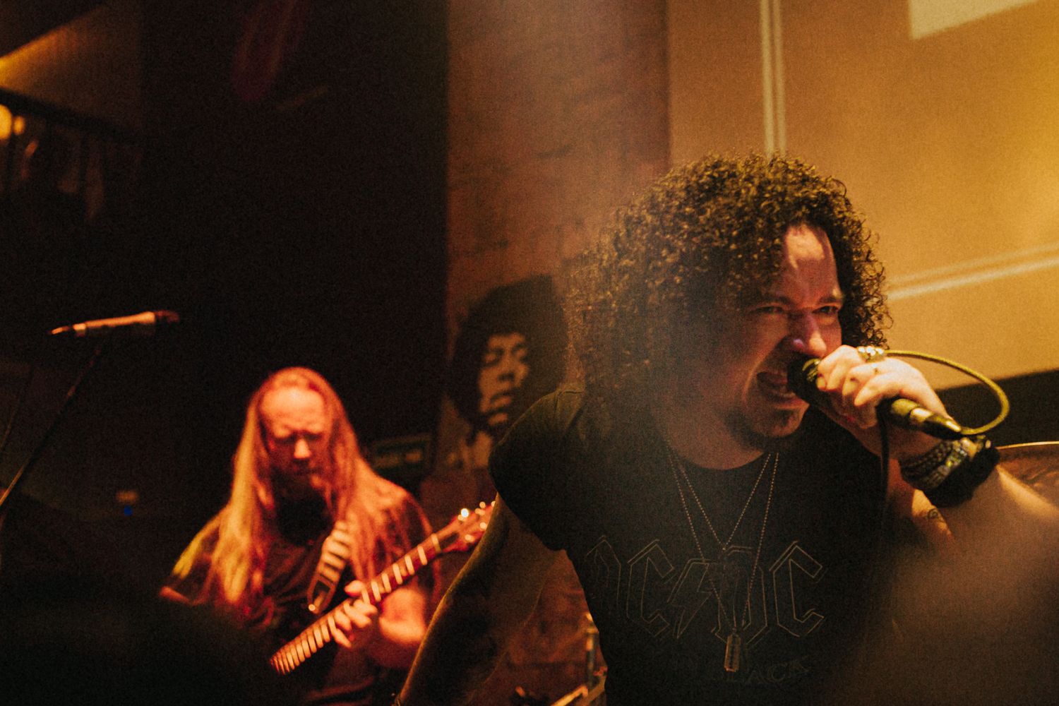 Epic metal photoshoots capturing intense performances—guitarists shredding, vocalists roaring, and dramatic stage lighting setting the mood.