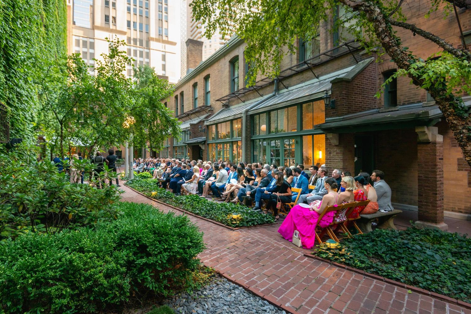 Garden courtyard event space with brick pathways and lush green landscaping.