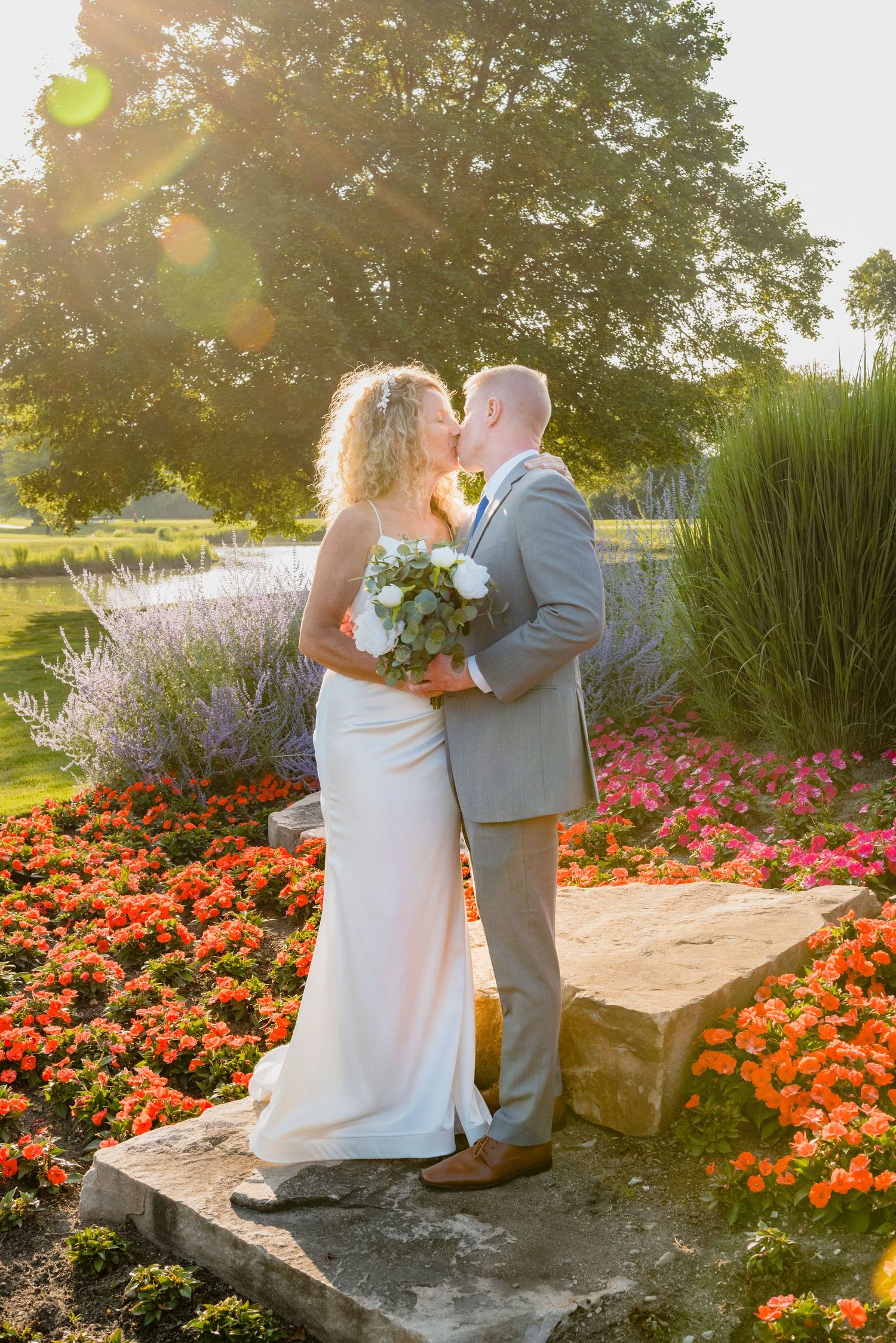 Sunset wedding photos in garden with colorful flowers and golden light.