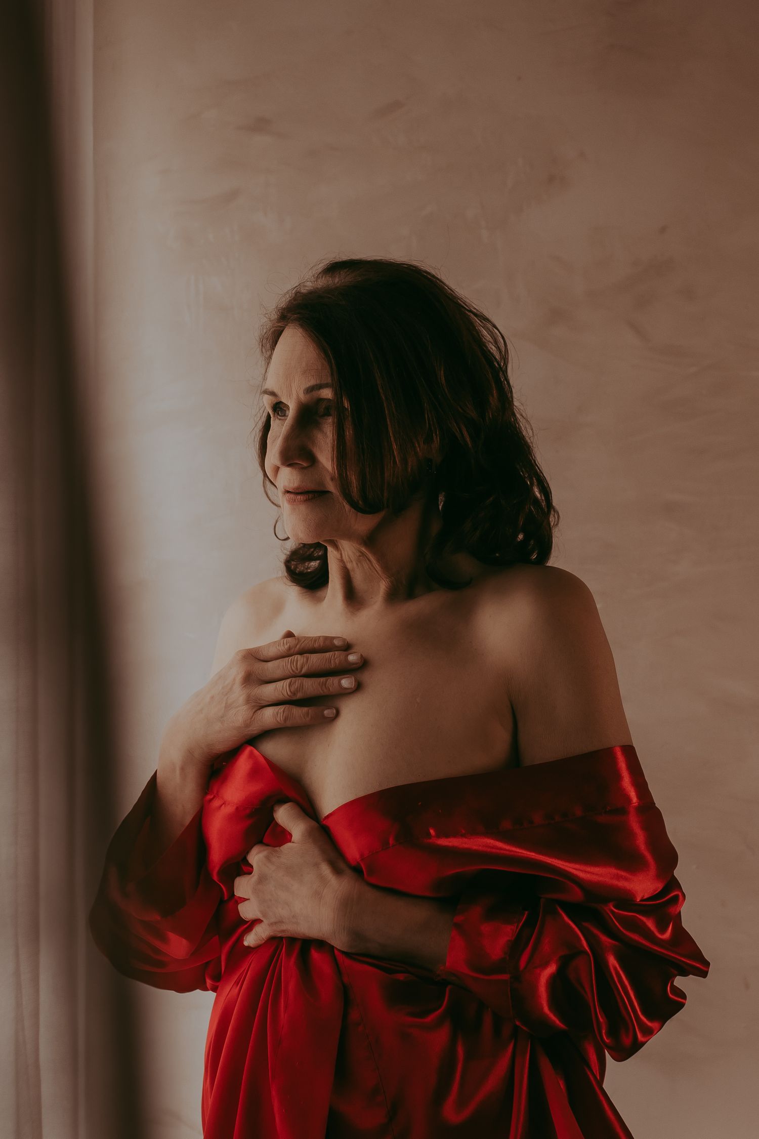 Oudere vrouw die een rode kimono om heeft in een donkere stijl