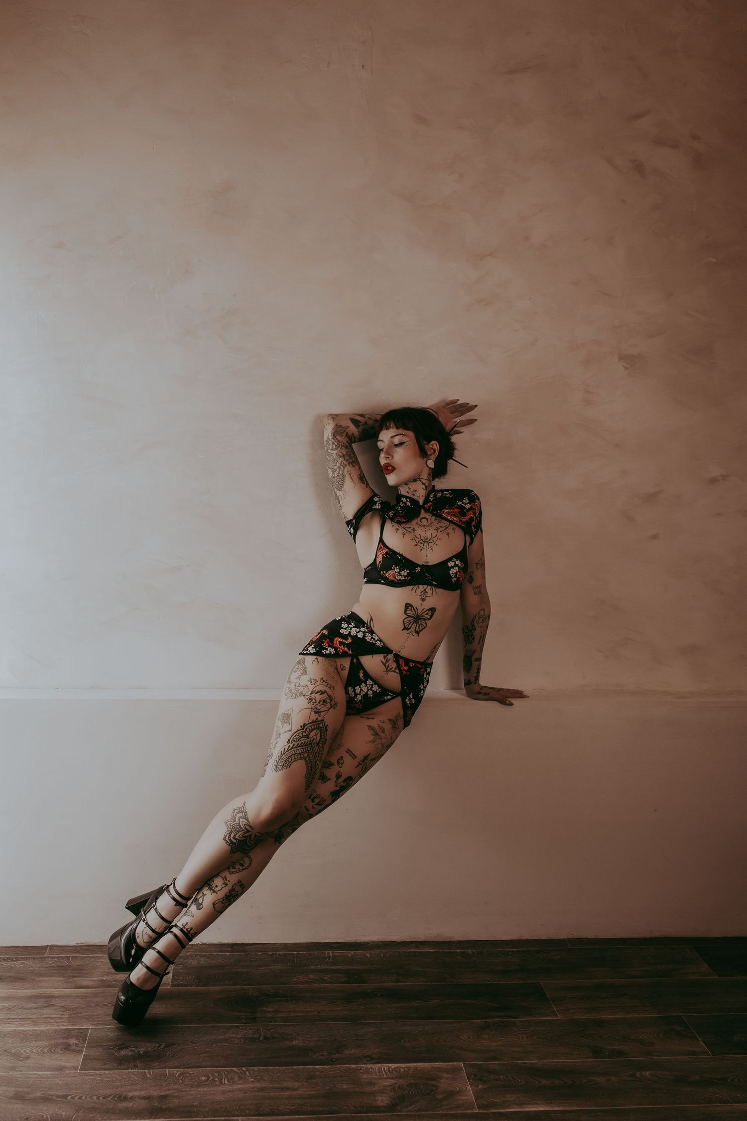 Vrouw met tattoos en een chinees lingerie setje en hoge hakken