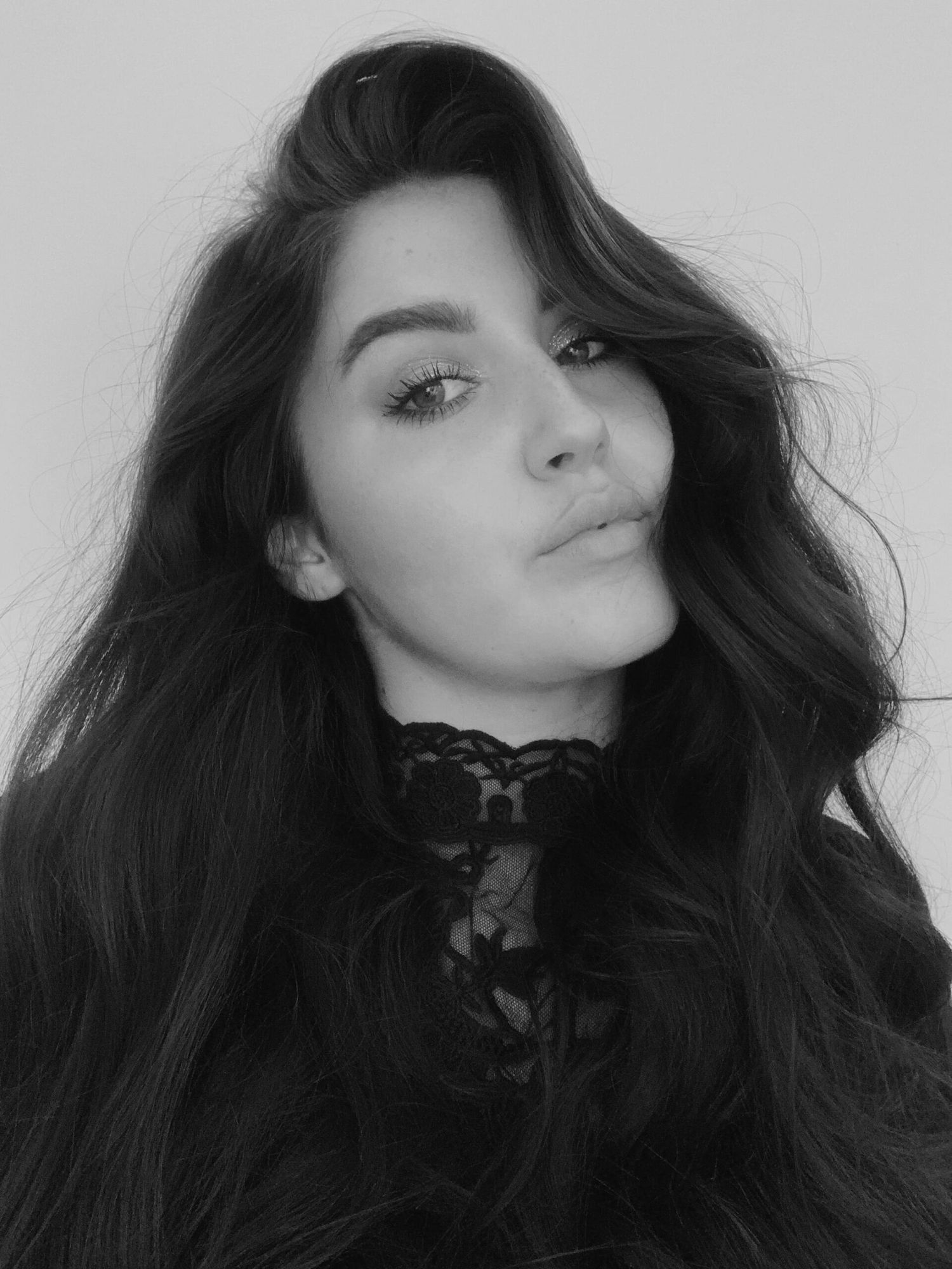 Black and white artistic portrait featuring lace collar and flowing dark hair.