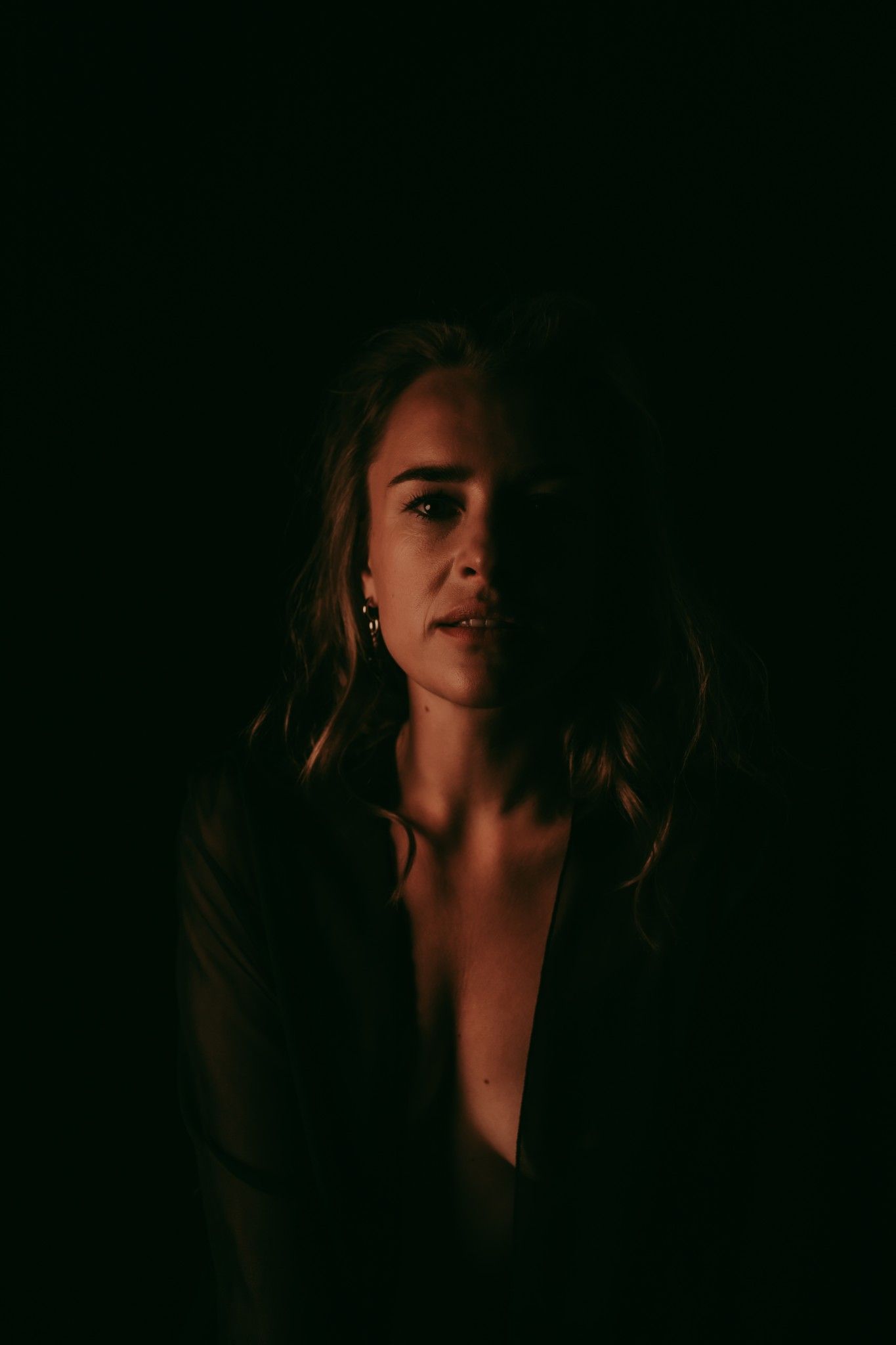Donkere portret foto van een vrouw met blonde haren en een zwarte kimono aan