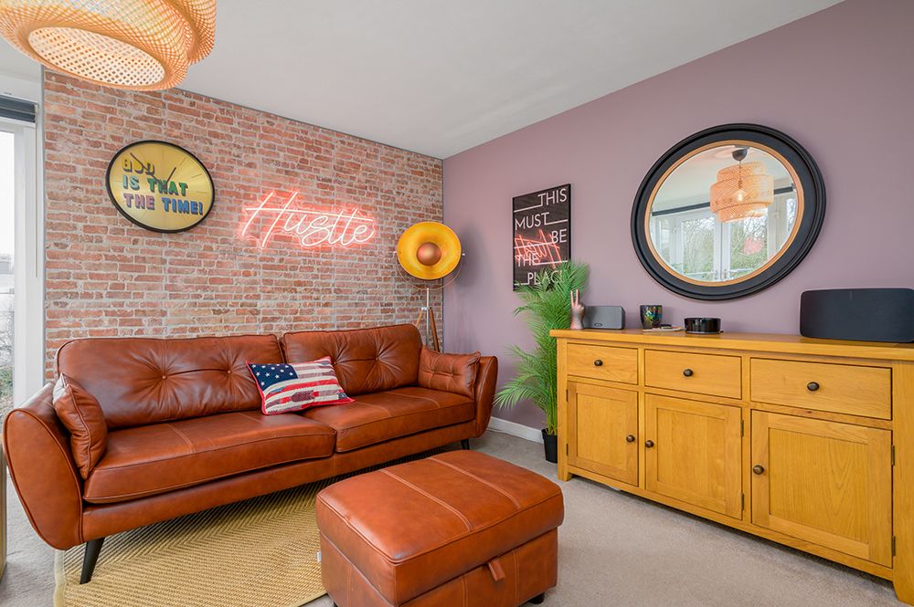 Trendy living space with brick wall effect and neon signs. Penthouse apartment photographed by Gavin Duncan Photography