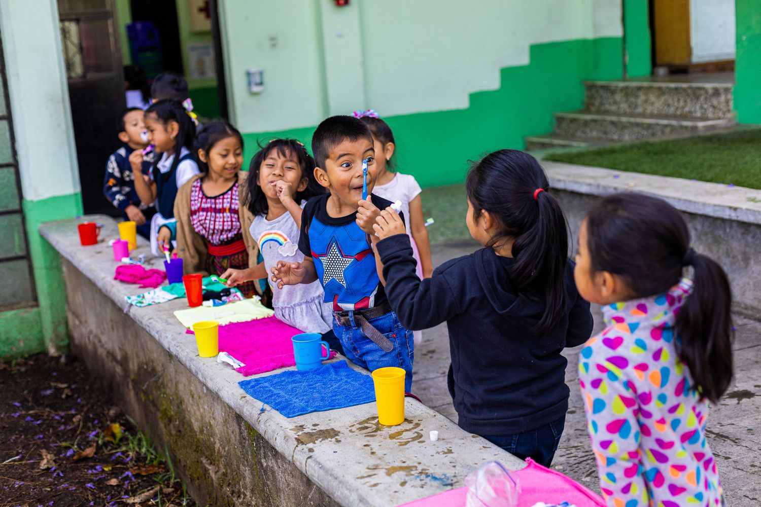 Students enjoy snack time outdoors on concrete benches.