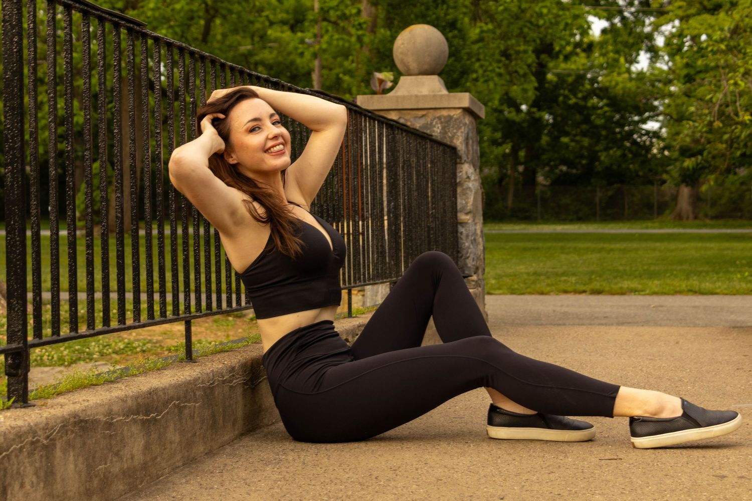 Central PA portrait solo session woman sitting on bridge holding hair with legs extended at Long's Park by Millie D'Auria Photography