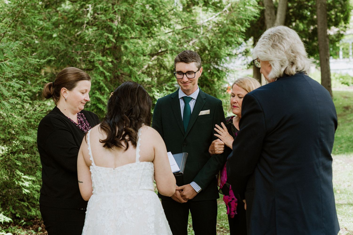 Bride and groom receive congratulations from guests following intimate outdoor wedding ceremony.