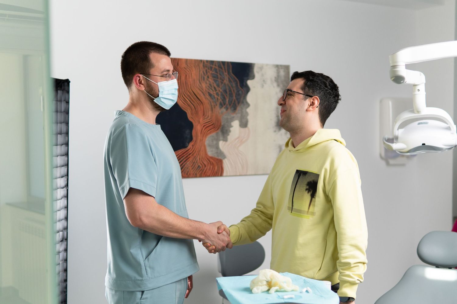 Medic dentist și pacient după consultație în clinica BelleDent